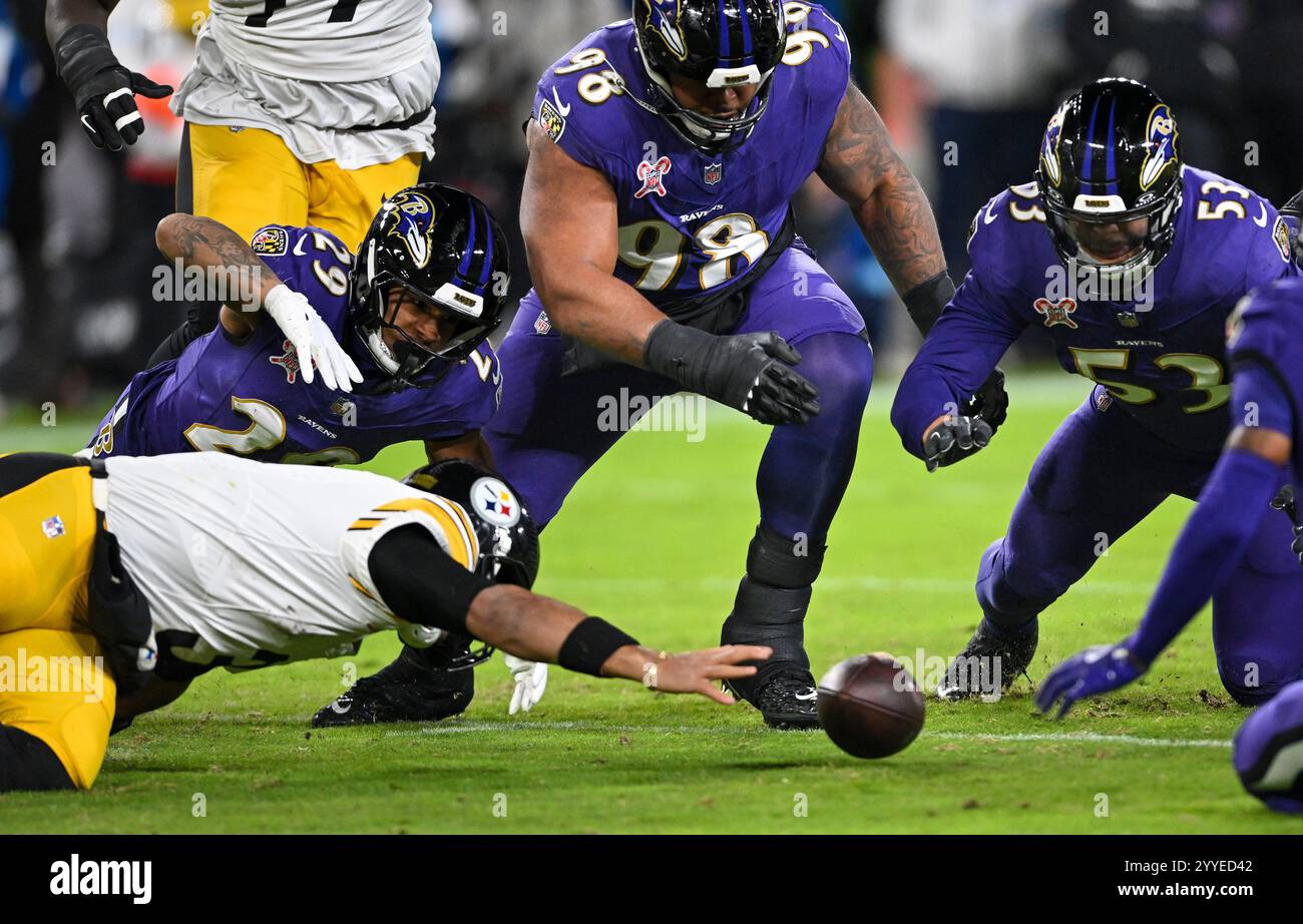 Baltimore, États-Unis. 21 décembre 2024. Russell Wilson (3), le quarterback des Pittsburgh Steelers, s'enfuit sous la pression de la sécurité des Ravens de Baltimore, AR'Darius Washington (29), du lineman défensif Travis Jones (98) et du linebacker Kyle Van Noy (53) pendant la première mi-temps au M&T Bank Stadium de Baltimore, Maryland, le samedi 21 décembre 2024. Photo de David Tulis/UPI crédit : UPI/Alamy Live News Banque D'Images