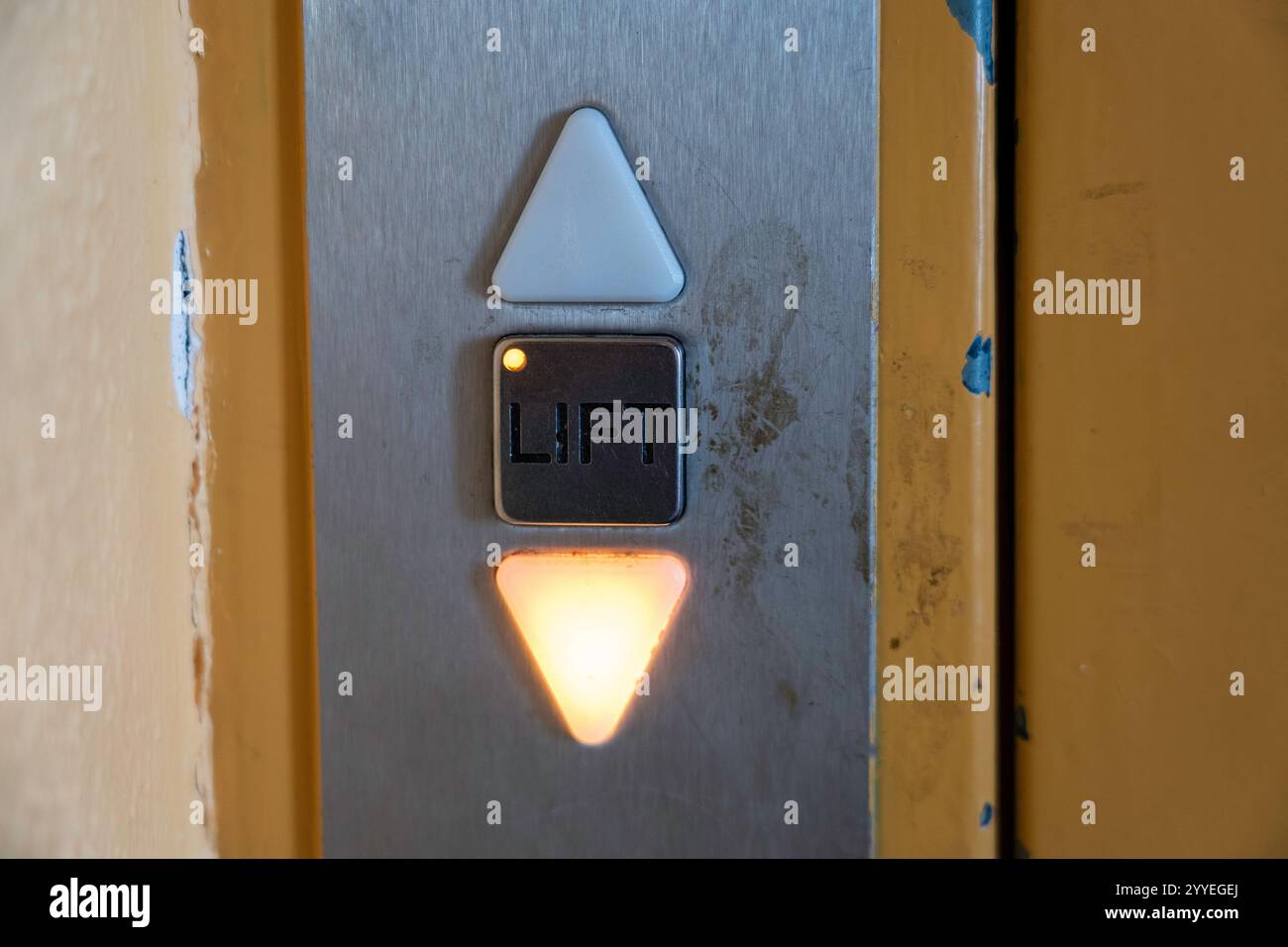 Panneau de commande de l'élévateur usé avec flèche vers le bas éclairée et bouton de levage Banque D'Images