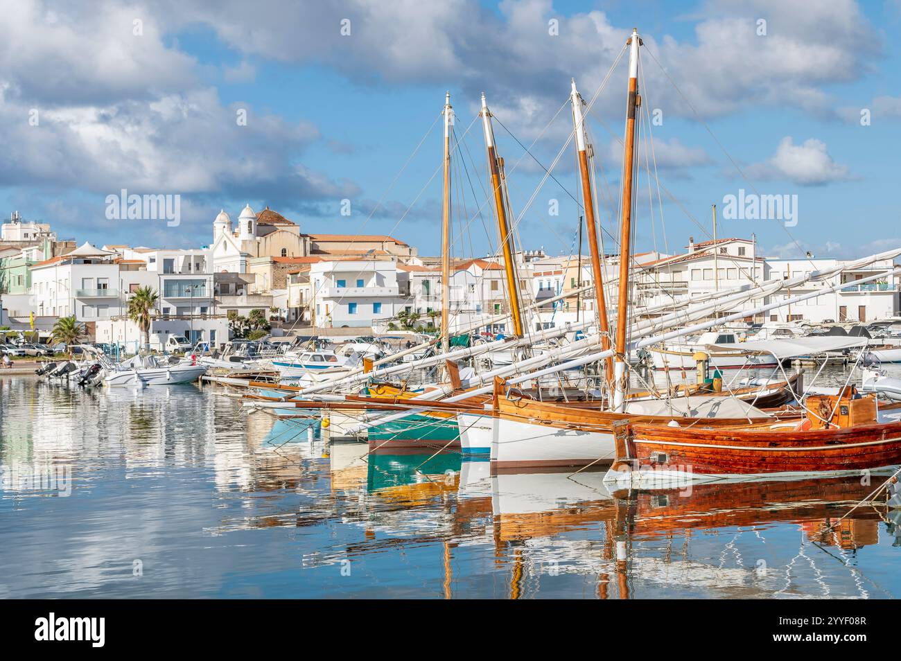 Les bateaux en bois colorés se reflètent dans l'eau du port de Calasetta, Sant'Antioco, Italie Banque D'Images
