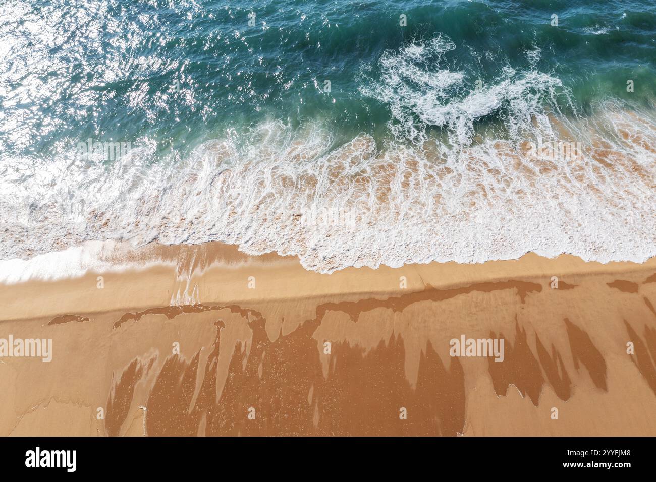 Eau de l'océan Azur et mousse de l'océan couvrant une belle longue plage de sable, vue aérienne drone. Beau fond de nature. Banque D'Images