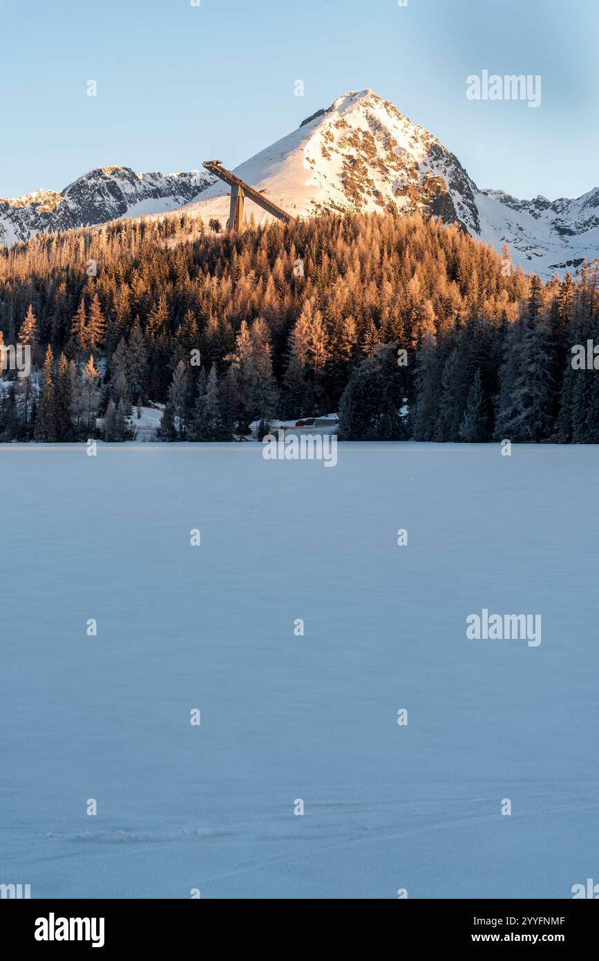 Strbske pleso lac avec Predne Solisko, Mlynicke et Strbske Solisko sommets de montagne au-dessus dans les montagnes des Hautes Tatras en Slovaquie pendant le matin d'hiver Banque D'Images