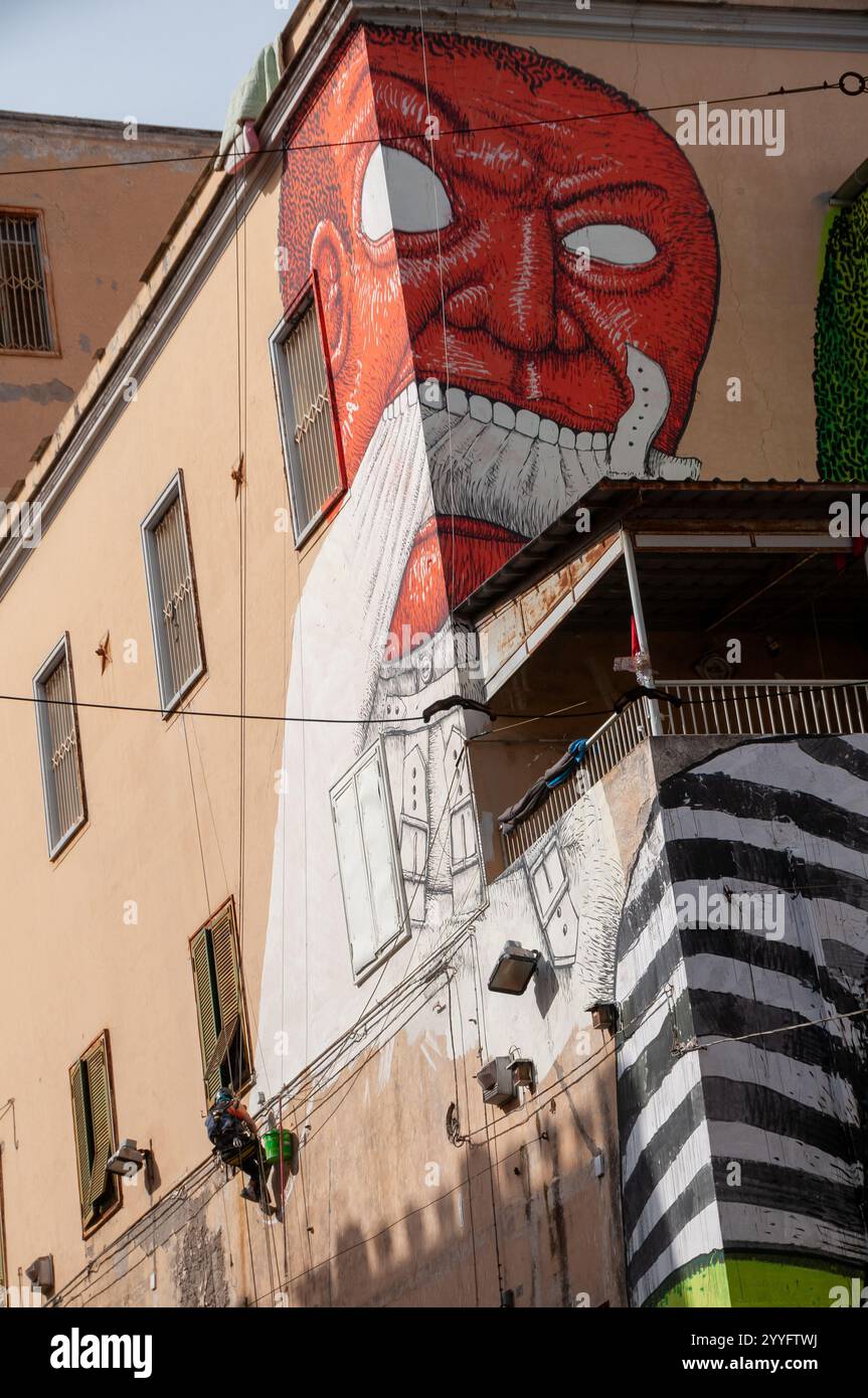 Street art du célèbre artiste Blu dessiné en direct sur la façade de l'ancien hôpital psychiatrique judiciaire (OPG) dans la via Matteo Renato Imbriani à Naples. Banque D'Images