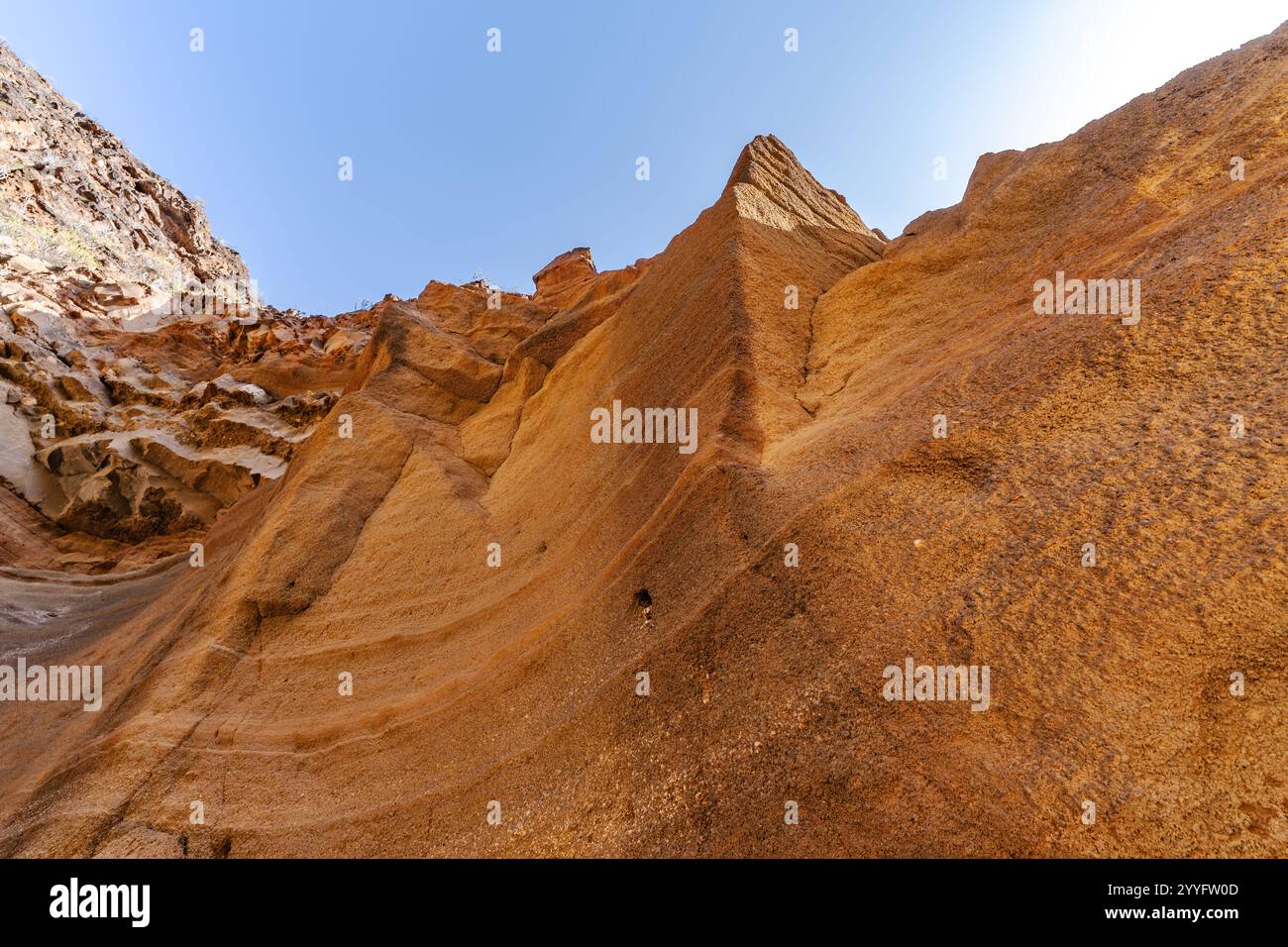 Une colline rocheuse avec un ciel bleu en arrière-plan. La colline est couverte de rochers et a une surface rocheuse et inégale Banque D'Images