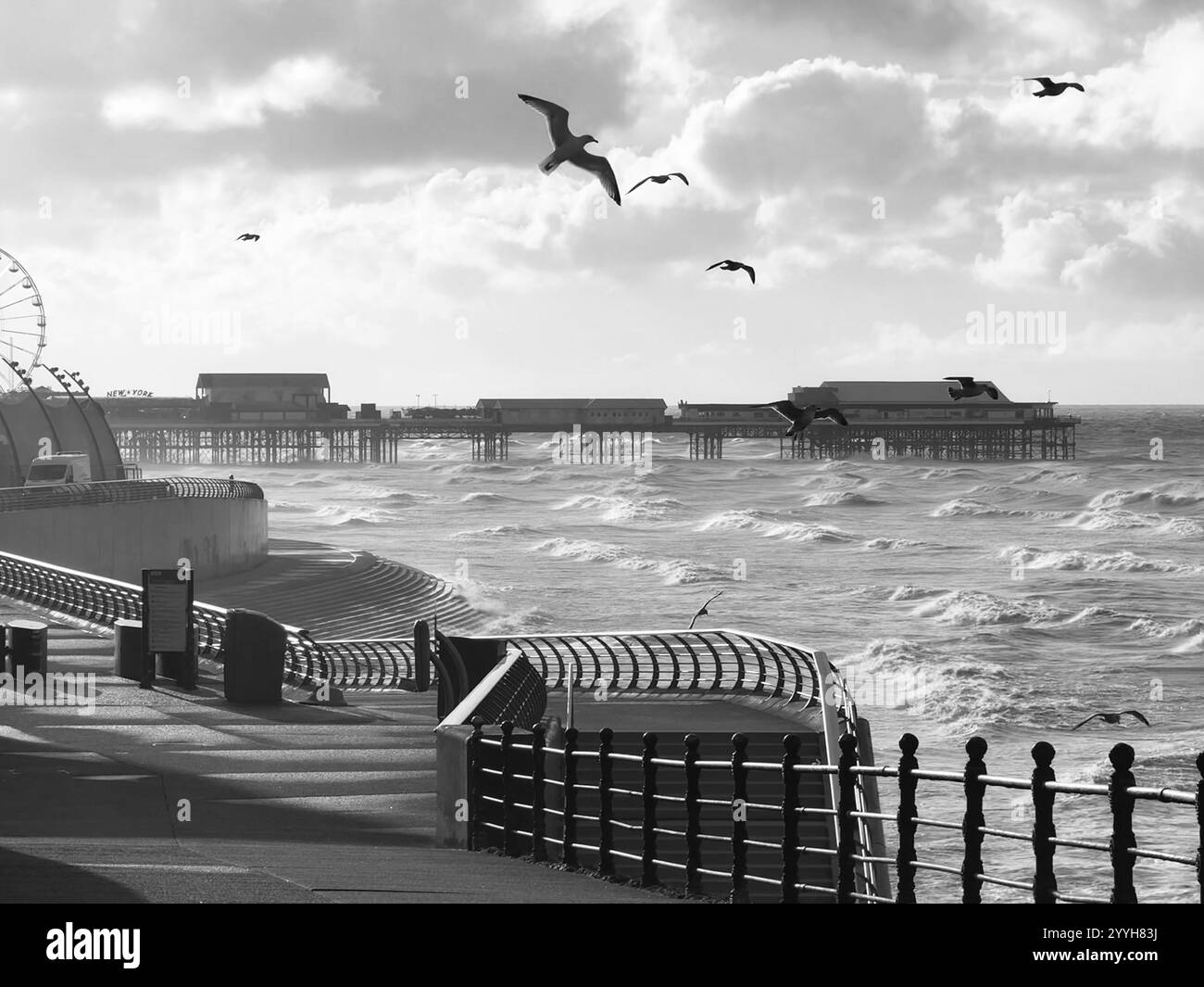 Journée d'hiver venteuse à Blackpool avec des goélands en vol au-dessus de la promenade. Avec Central Pier au loin. Banque D'Images
