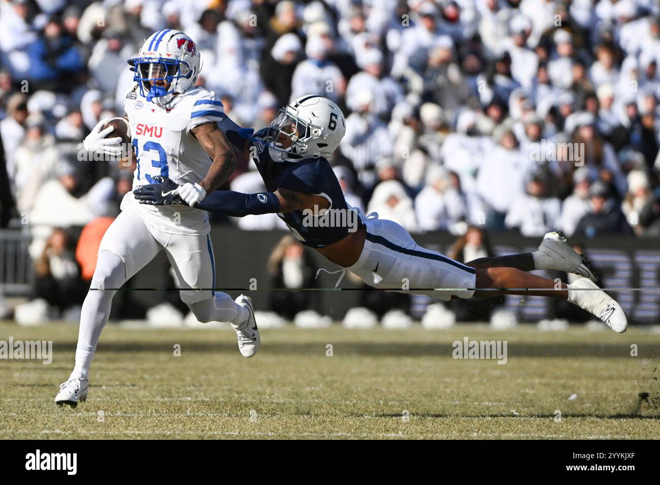 Penn State safety Zakee Wheatley (6) tackles SMU wide receiver Roderick Daniels Jr. (13) during the first half in the first round of the College Football Playoff, Saturday, Dec. 21, 2024, in State College, Pa. (AP Photo/Barry Reeger) Banque D'Images