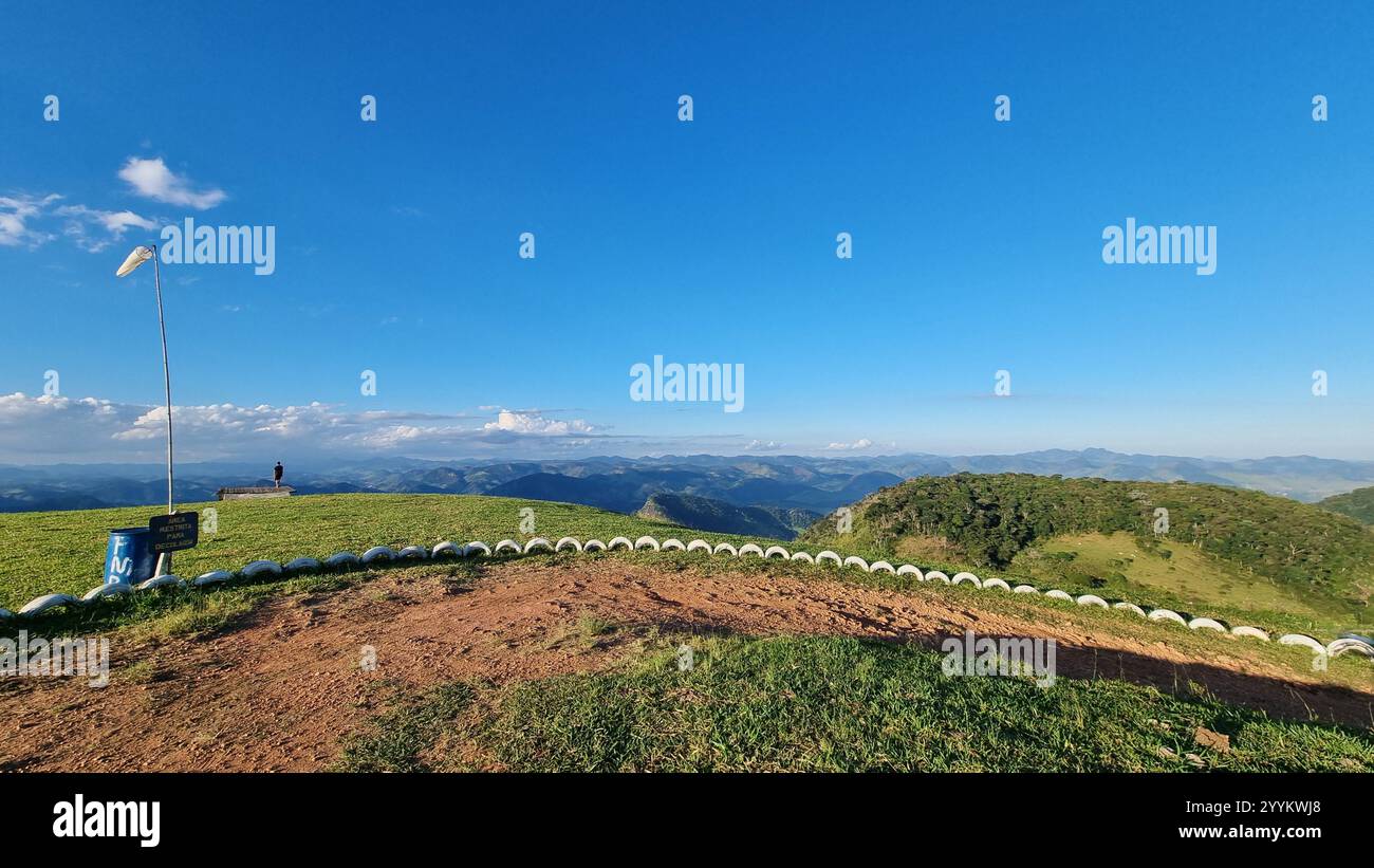 Cette photo à couper le souffle capture une colline sereine avec un champ d'herbe vert luxuriant s'étendant sous un ciel bleu vif parsemé de cl doux et dispersé - Image de stock capturée avec un smartphone