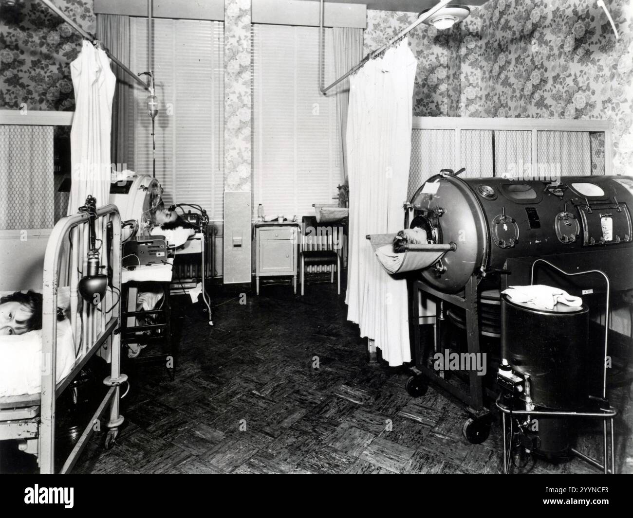 poumons de fer. Les salles de polio étaient garnies non seulement de lits, mais aussi de poumons en fer, de grands ventilateurs métalliques qui aidaient les patients à respirer pendant le pire de l'infection. Certains survivants n'ont jamais retrouvé la fonction pulmonaire et ont passé le reste de leur vie dans les appareils. (Crédit : U.S. Food and Drug Administration) Banque D'Images