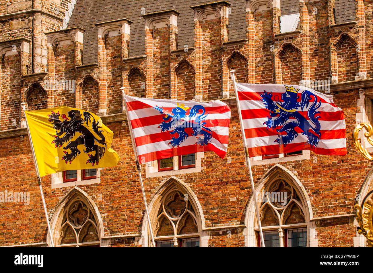 Drapeau jaune de la Flandre et des bandes blanches rouges avec lion bleu est le drapeau de Bruges sur le bâtiment à Bruges, Flandre occidentale, Belgique. Banque D'Images