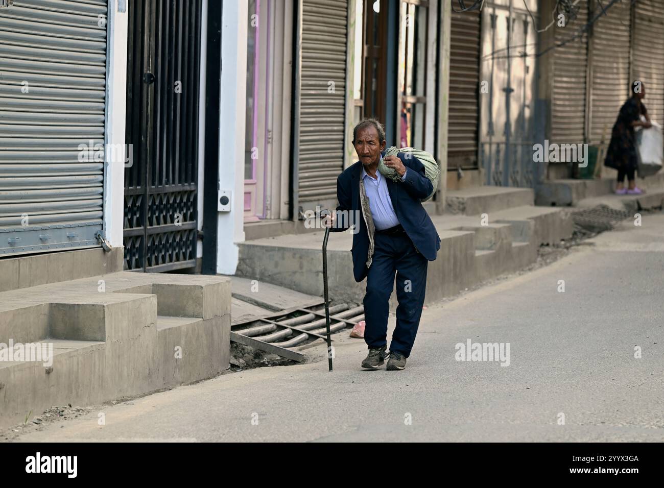 Un homme népalais âgé marchant dans une rue par un automne chaud à Thamel, Katmandou, Népal. Banque D'Images