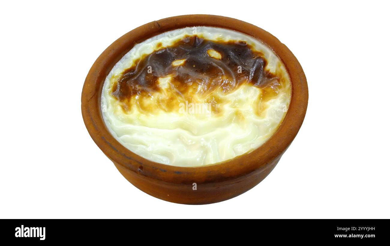 Dessert turc Sutlac, alias Firin Sutlac isolé sur blanc. Riz cuit au four Pudding dans un pot en argile. Banque D'Images