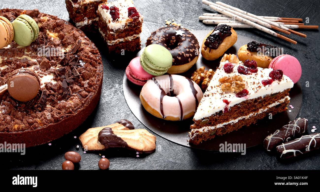 Assortiment de confiseries, différents types de desserts sur table sombre. Banque D'Images