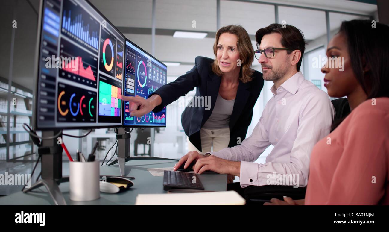 Groupe diversifié d'étudiants apprenant l'analyse commerciale sur des écrans d'ordinateur. Banque D'Images