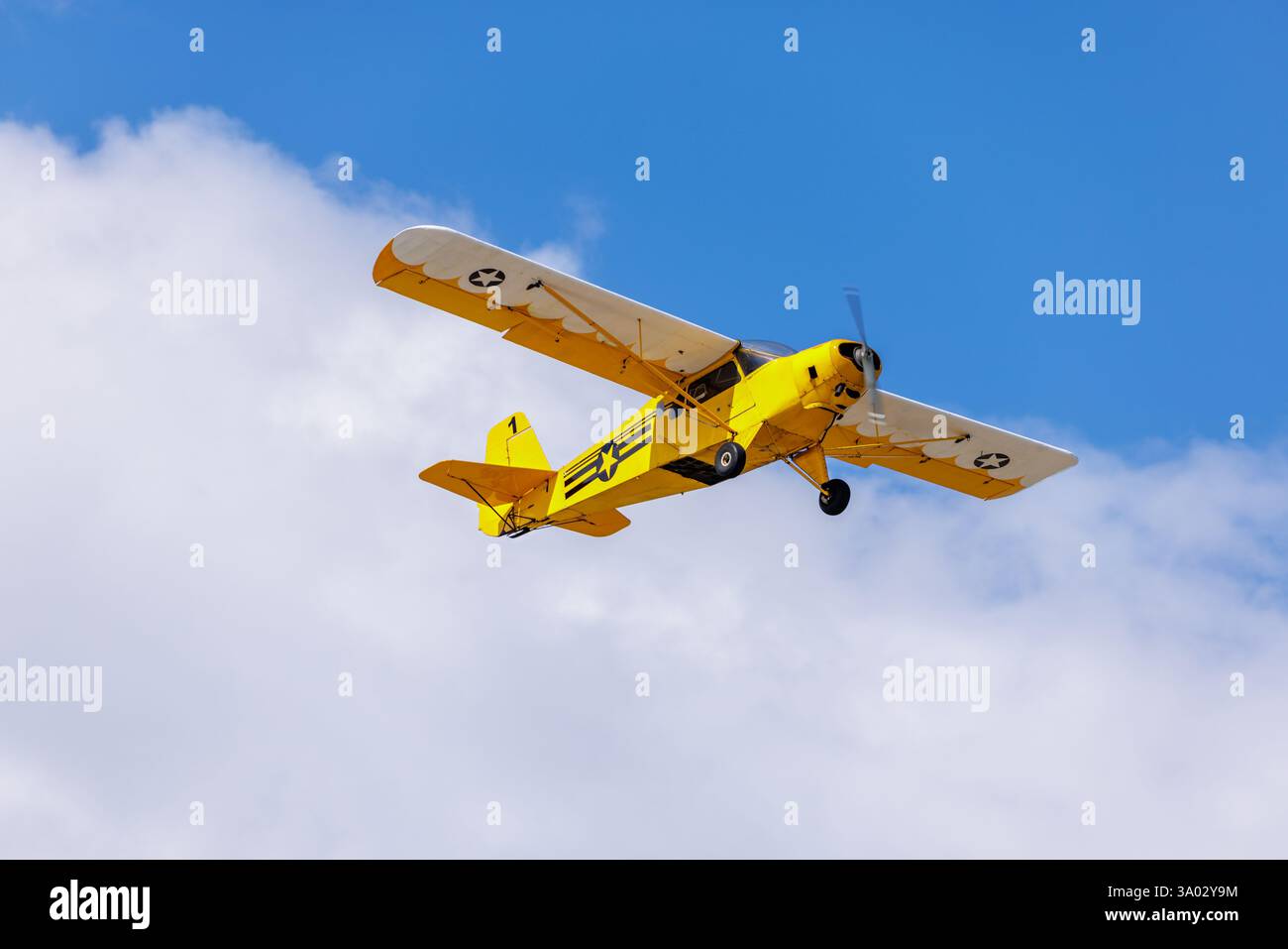 Avion jaune volant au-dessus du ciel bleu. Banque D'Images