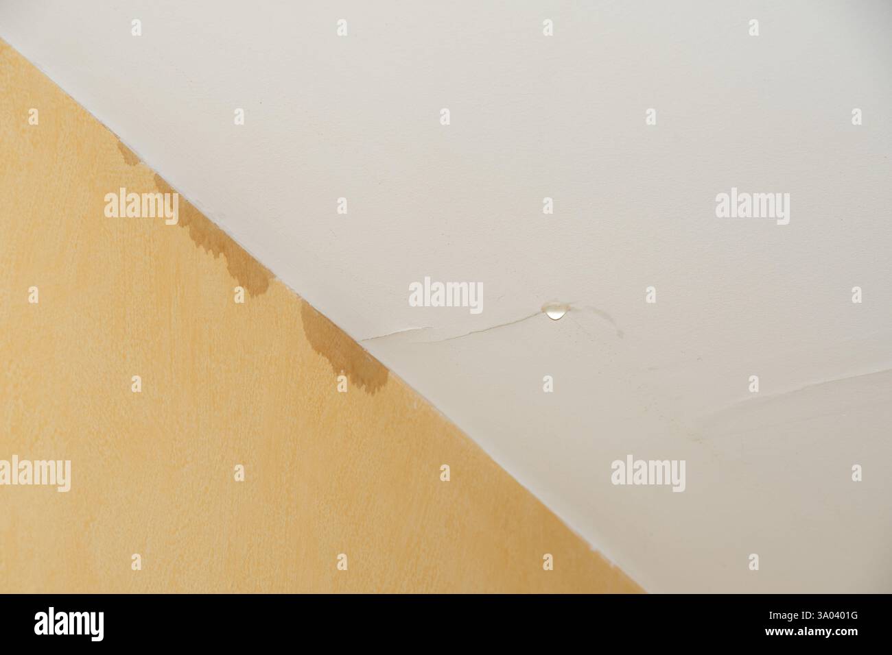 Dégâts d'eau sur le plafond avec taches visibles et fissure dans l'intérieur jaune Banque D'Images