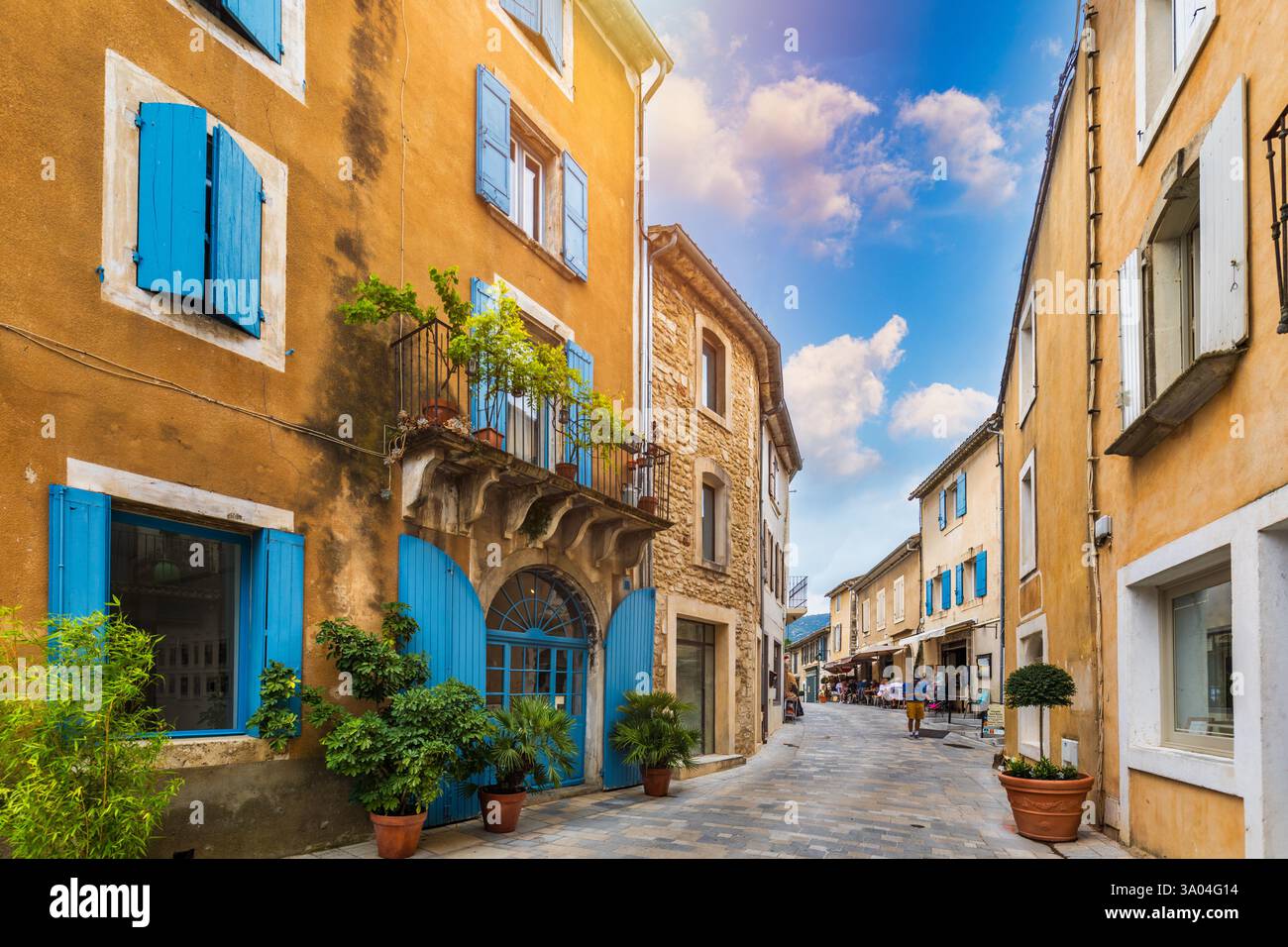 Charmante rue dans le village pittoresque de Menerbes avec des bâtiments colorés et des fleurs vibrantes. Village de Menerbes (plus beau Village de France) dans le Banque D'Images