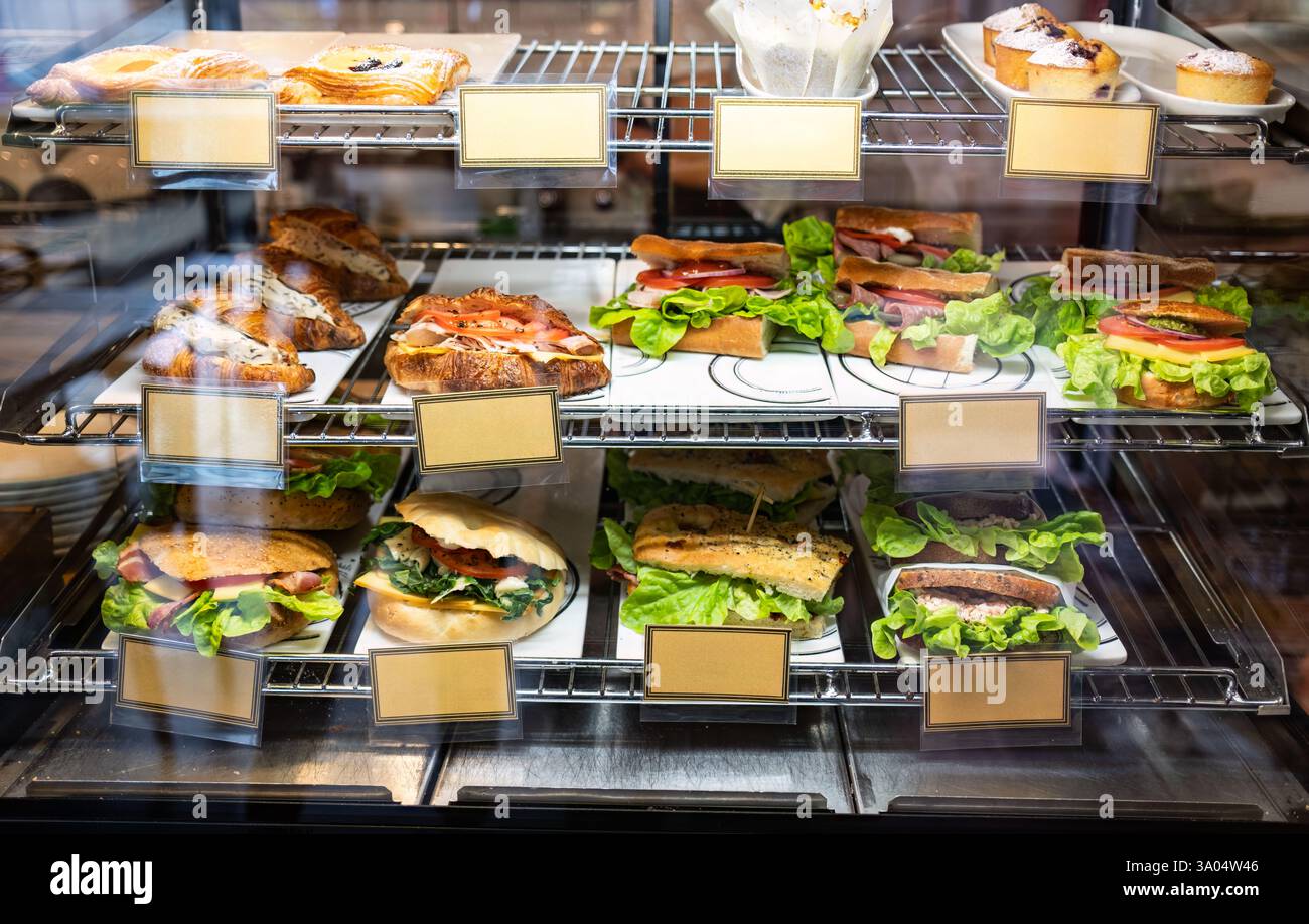 Vitrine avec étiquette de prix de sandwichs, hamburger et pâtisseries dans le café Banque D'Images