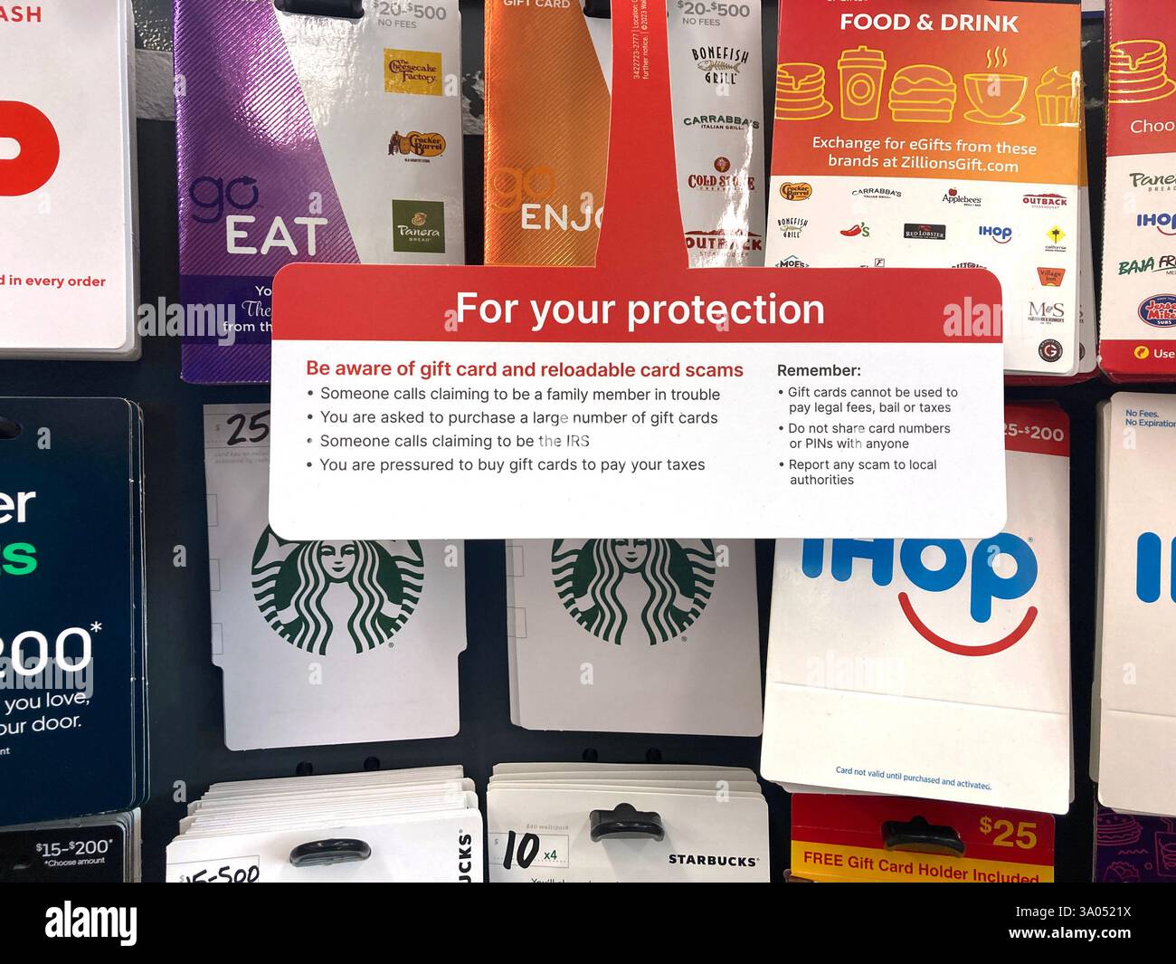 La présente invention concerne un présentoir de cartes-cadeaux avec un panneau d'avertissement concernant les escroqueries par cartes-cadeaux et cartes rechargeables, conseillant aux acheteurs de rester vigilants en cas d'activités frauduleuses. Gros plan Banque D'Images