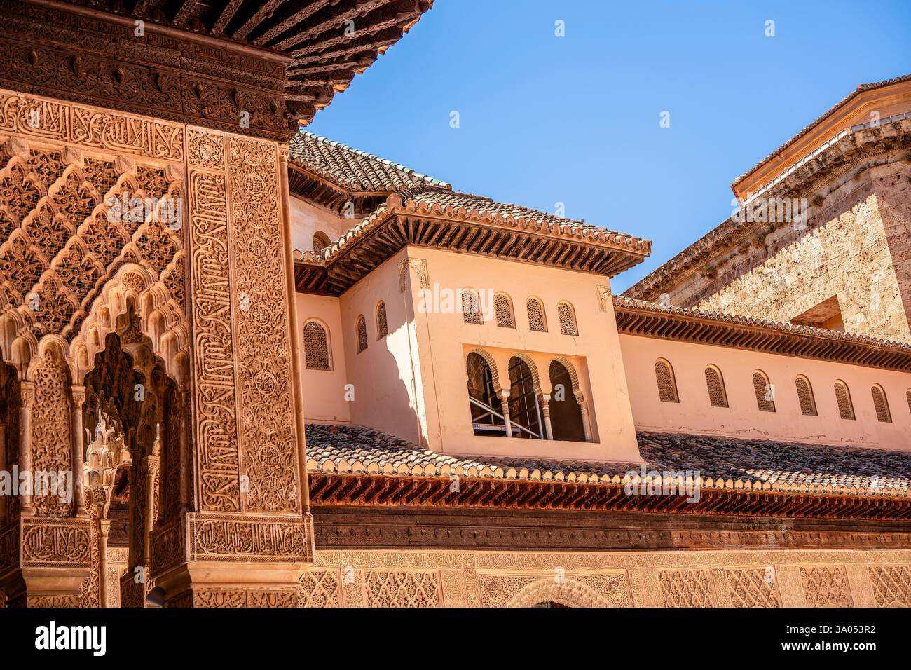 Arcades en stuc ornées et galeries supérieures dans la Cour des Lions à l'Alhambra présentant des sculptures nasrides, des arches en fer à cheval et des artisans andalous Banque D'Images