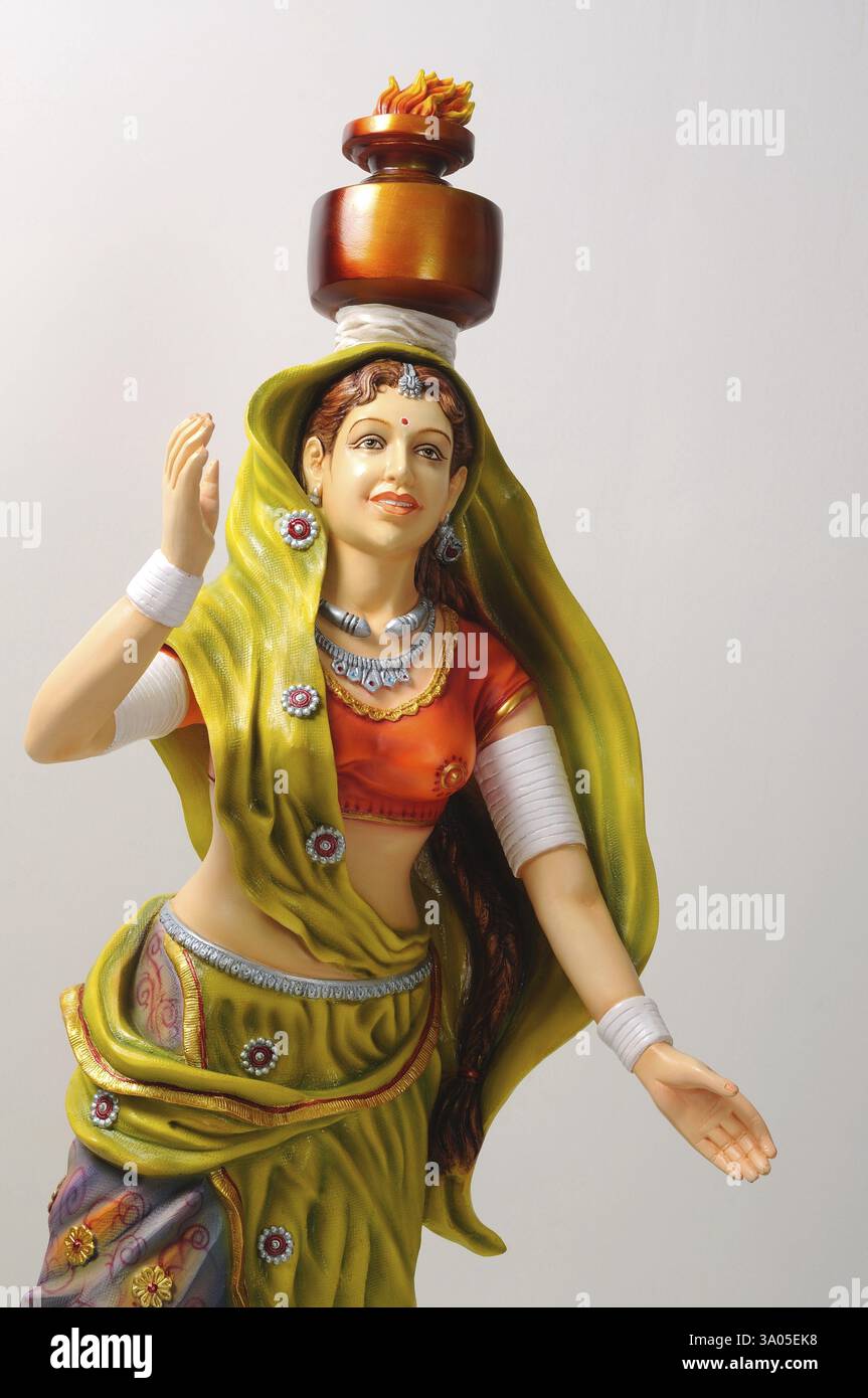 Figurine d'argile, statue de garba jouant femme rajasthani en sari avec pot sur sa tête ayant le feu dessus Banque D'Images