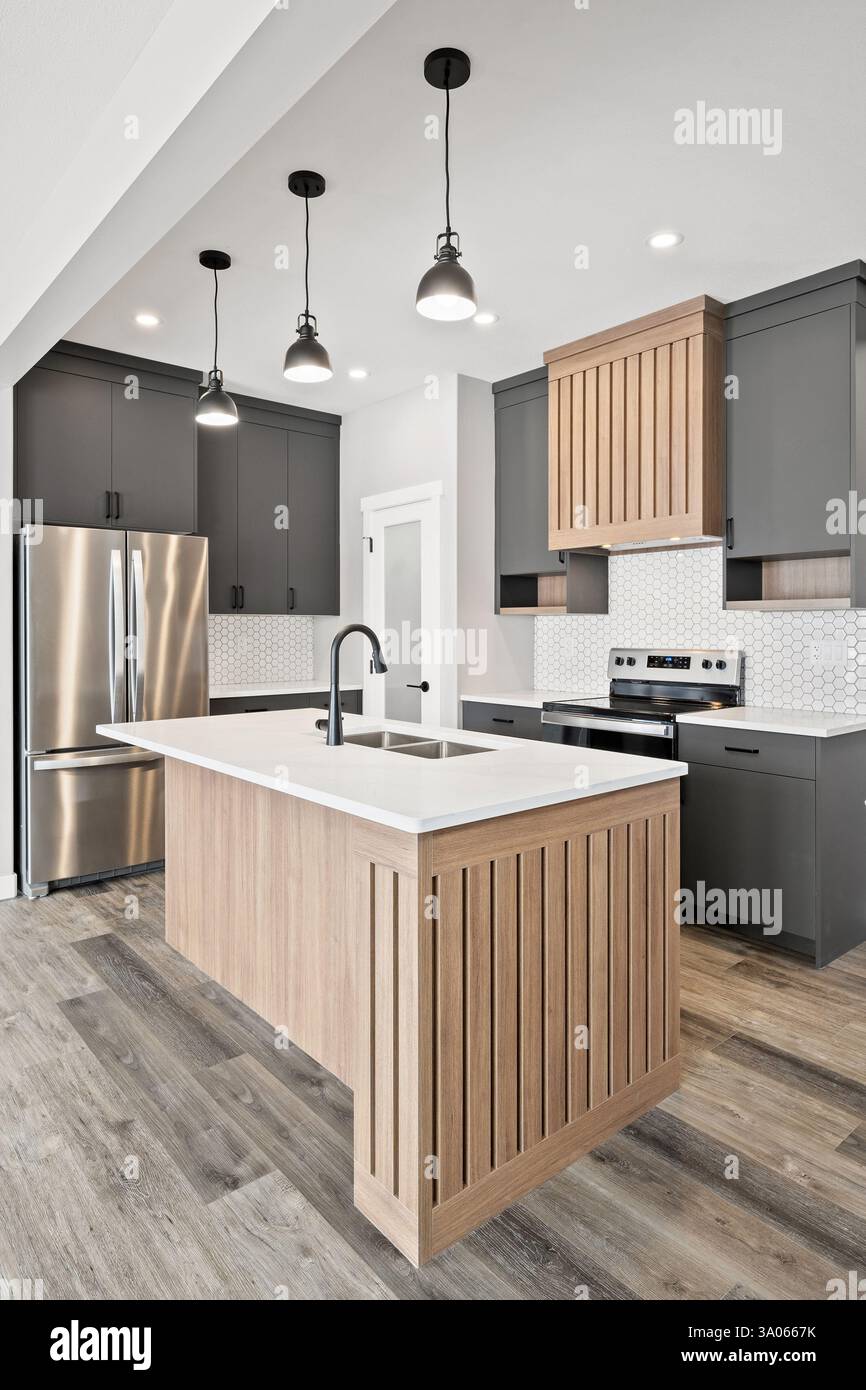 Cuisine avec îlot en bois et appareils électroménagers en acier inoxydable. La cuisine a un design moderne et élégant Banque D'Images