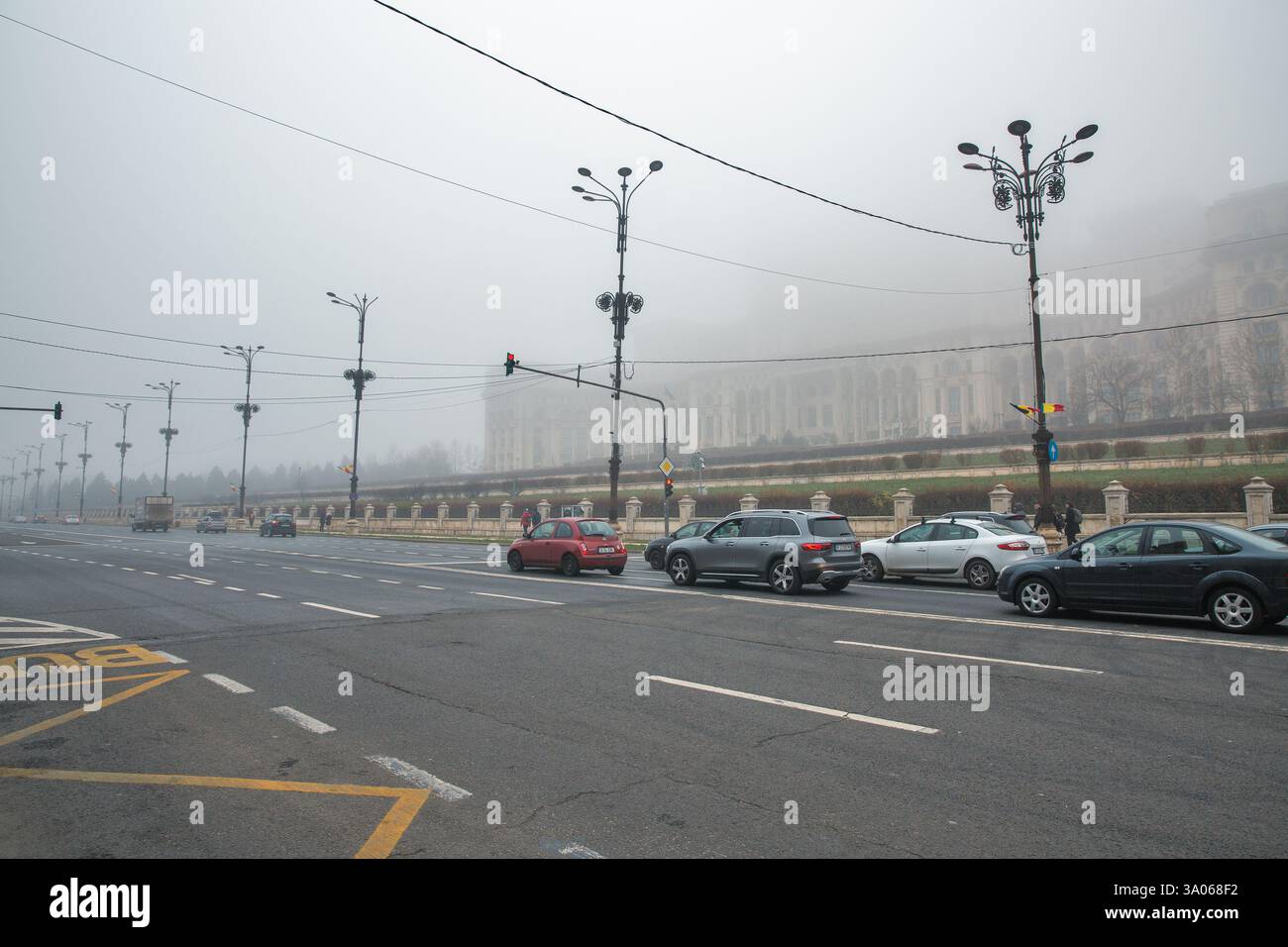 Bucarest, Roumanie - 31 décembre 2024 : Boulevard de la liberté et Palais du Parlement pendant un épais brouillard en hiver. Banque D'Images
