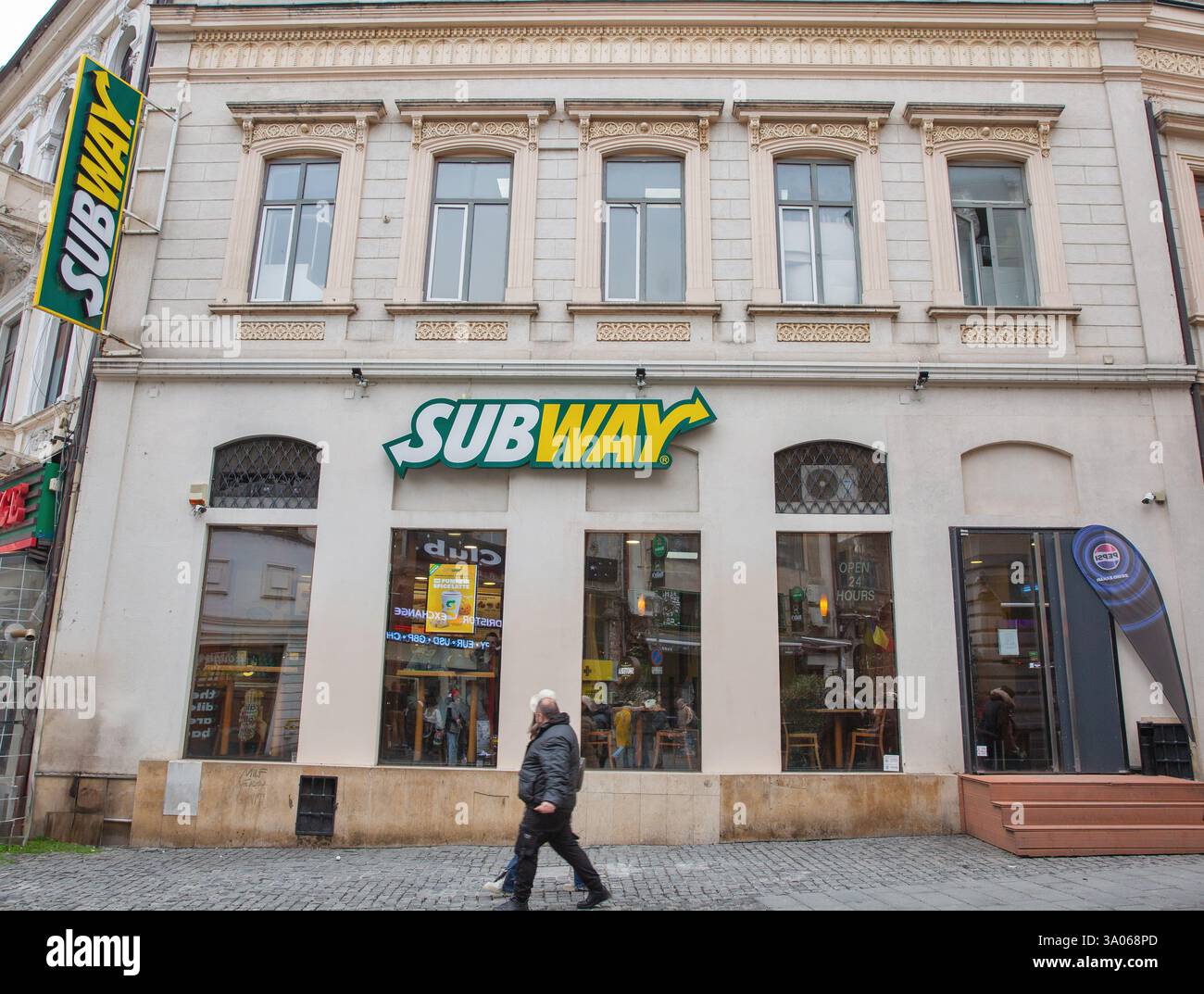 Bucarest, Roumanie - 31 décembre 2024 : les gens visitent le snack-bar Subway dans la vieille ville. Il s'agit d'une franchise de restauration rapide multinationale américaine, spe Banque D'Images