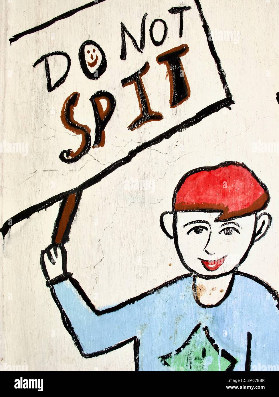 Peinture murale peinte à la main à l'extérieur d'une école de Kolkata décourageant de cracher dans les espaces publics, mettant en vedette une figure caricaturale tenant une pancarte indiquant « ne crachez pas ». Banque D'Images