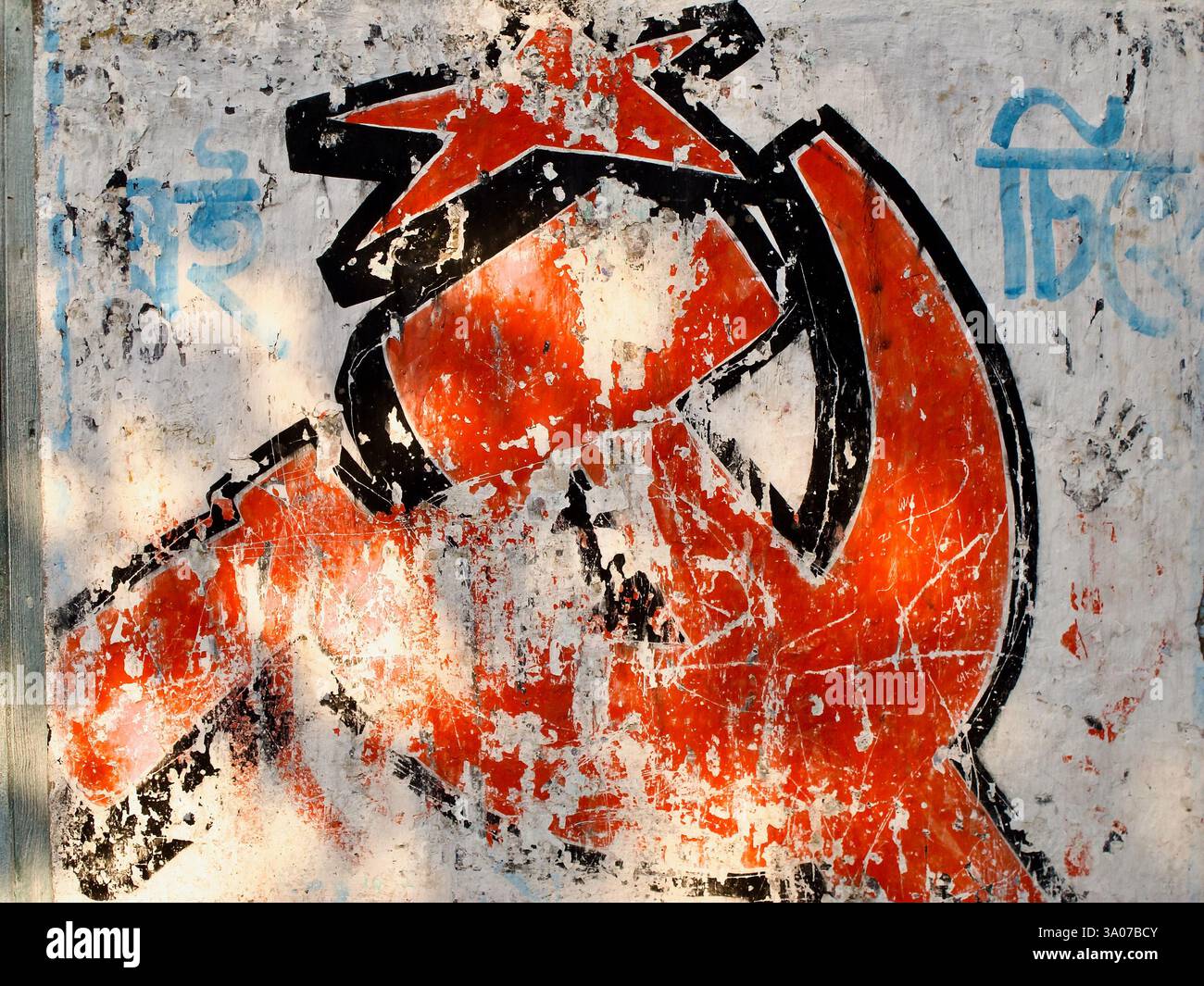 Marteau délavé et murale en faucille sur un mur altéré à Kolkata, reflétant l'héritage de l'influence communiste au Bengale occidental. Banque D'Images