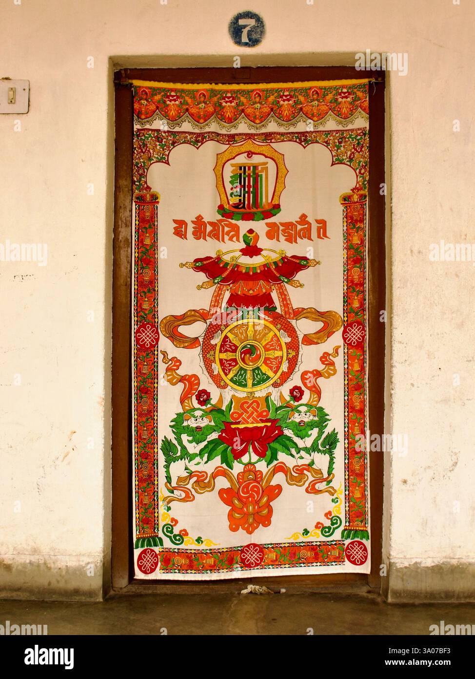 Porte tibétaine suspendue avec des symboles bouddhistes au monastère tibétain de Tergar à Bodh Gaya, Bihar, un site important pour le pèlerinage bouddhiste. Banque D'Images