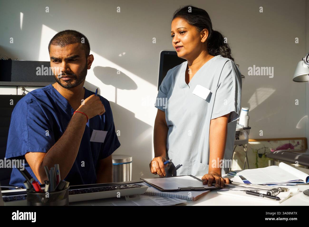 Médecin féminin debout près du médecin masculin tout en discutant dans la clinique médicale à l'hôpital Banque D'Images