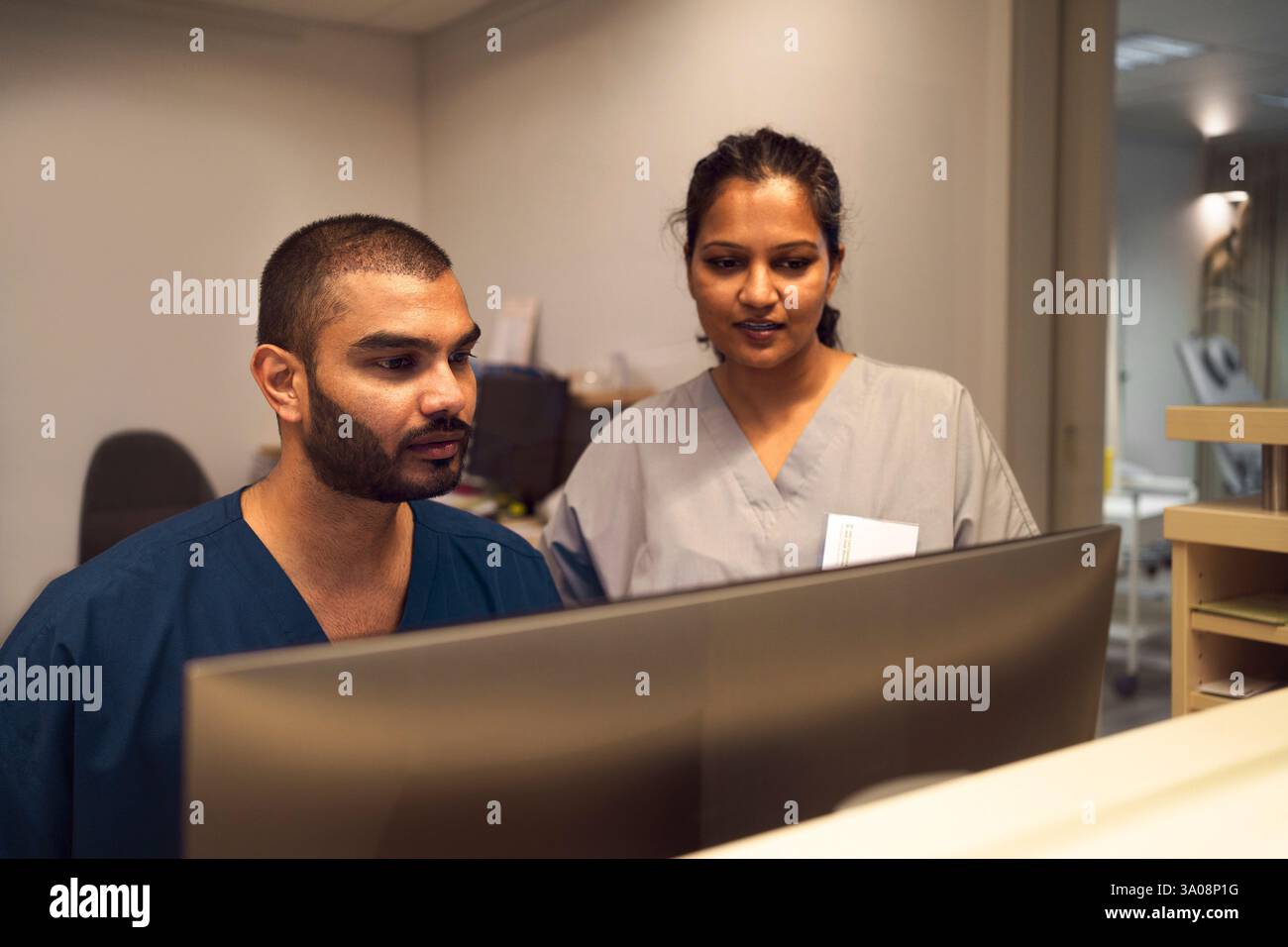 Professionnel médical masculin et féminin travaillant sur PC de bureau en clinique Banque D'Images