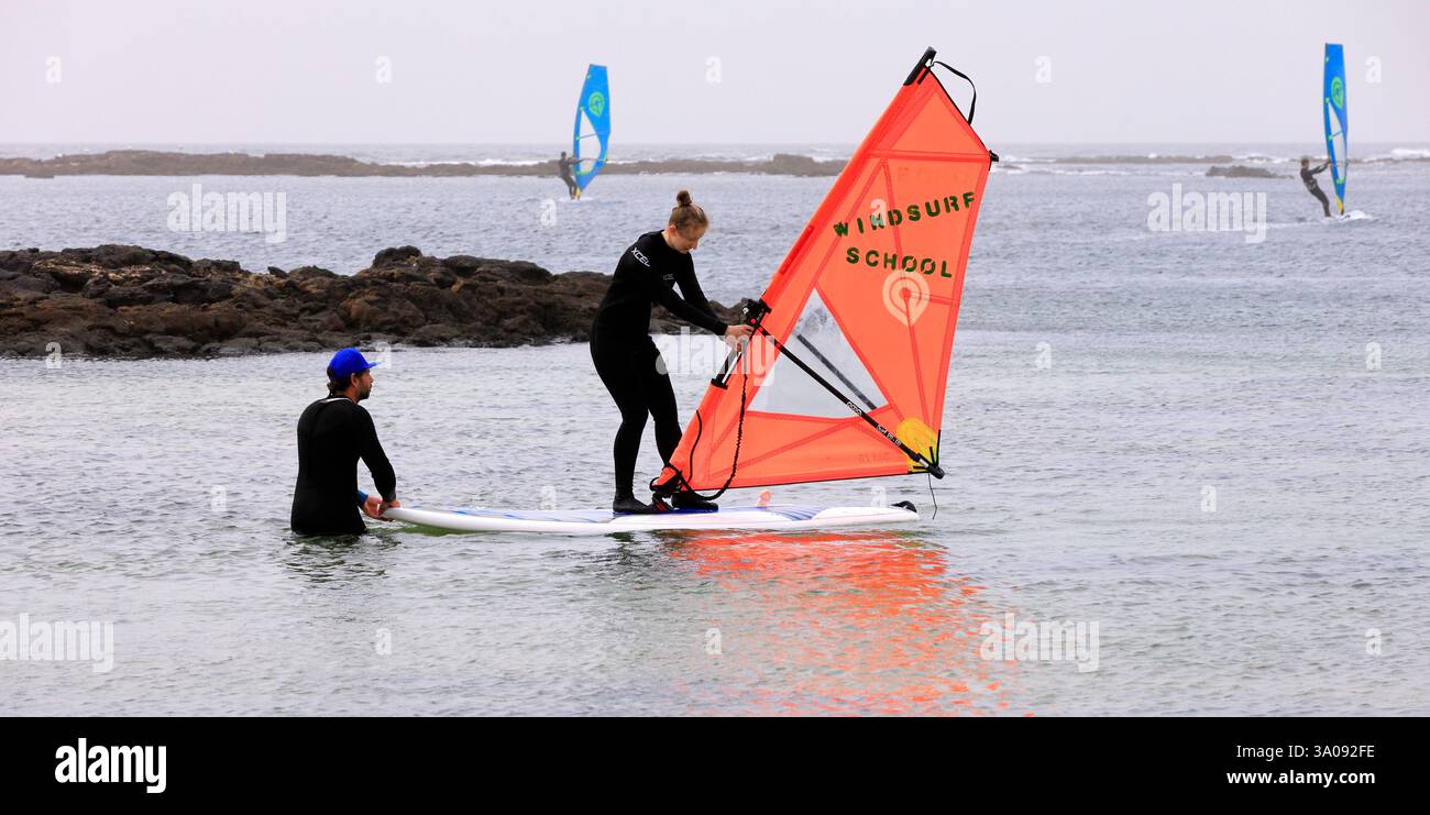 Jeune femme prenant cours de planche à voile à El Cotillo, Fuerteventura. Prise décembre 2024.Winter Banque D'Images