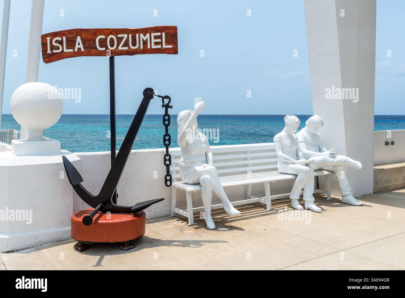 San Miguel de Cozumel, Mexique - 4 avril 2024 : sculptures de jeunes gens avec des smartphones assis sur un banc dans le port de croisière de Cozumel, Mexique. À t Banque D'Images