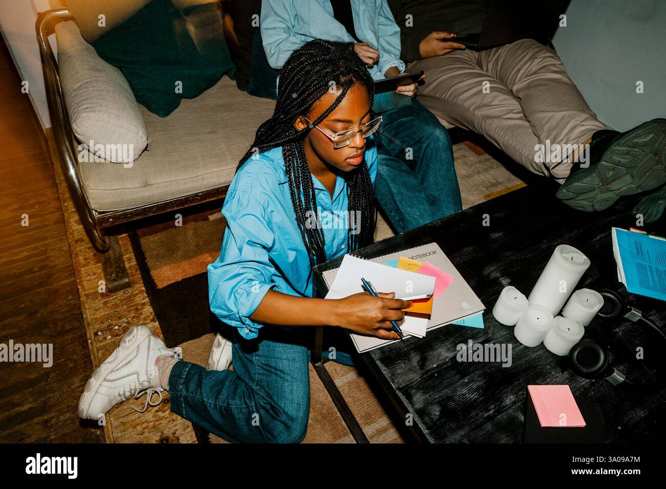 Vue en angle élevé d'une femme entrepreneure préparant des notes tout en étant assise sur le sol Banque D'Images