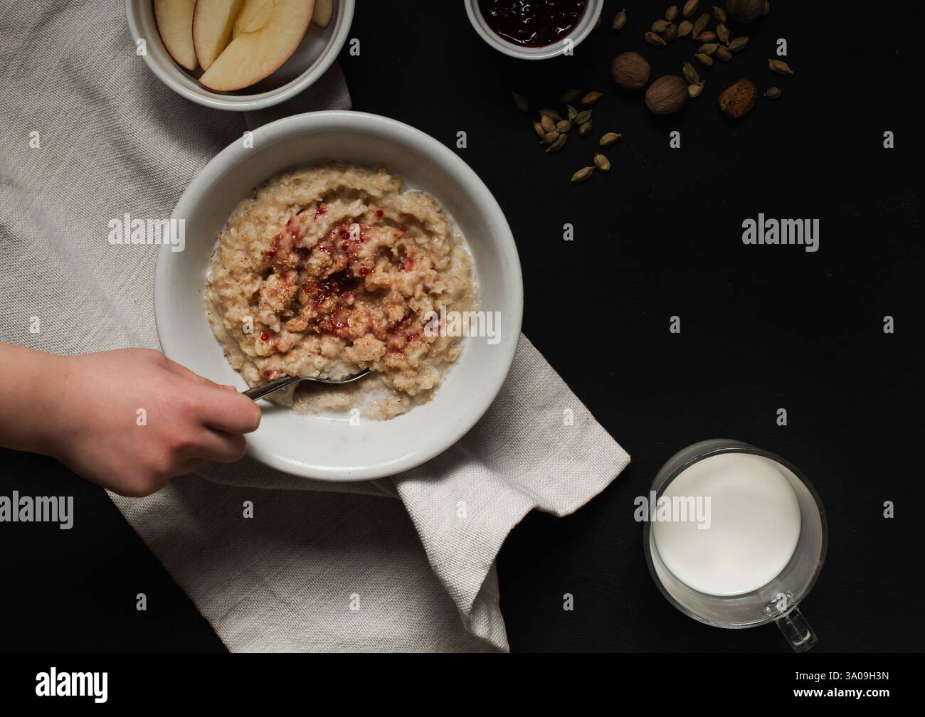 Enfant remuant un bol chaud de flocons d'avoine avec des fruits Banque D'Images