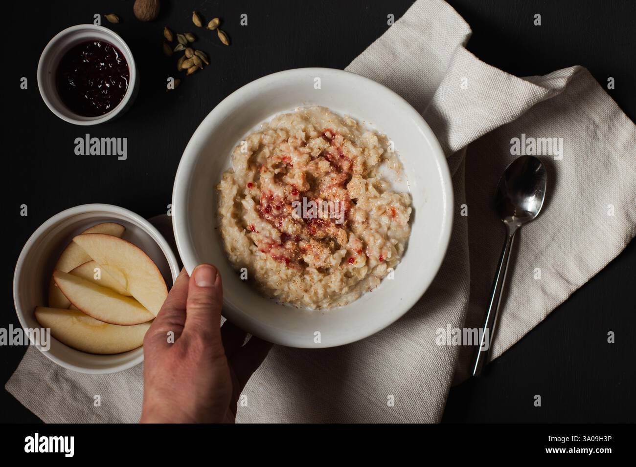 Personne tenant un bol de flocons d'avoine avec des pommes Banque D'Images