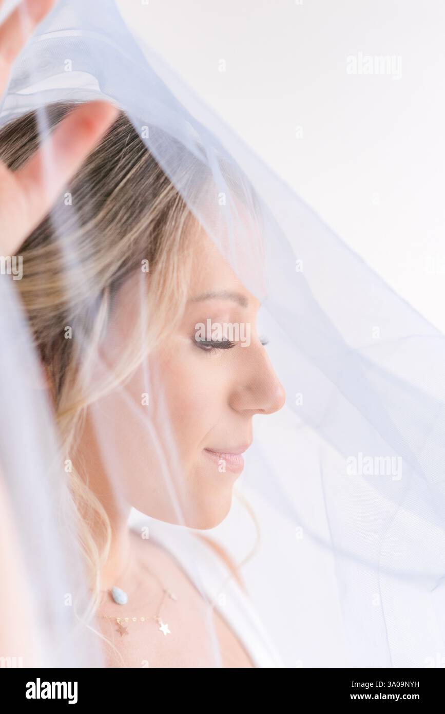 Gros plan éthéré d'une mariée avec un voile bleu doux, exsudant élég Banque D'Images