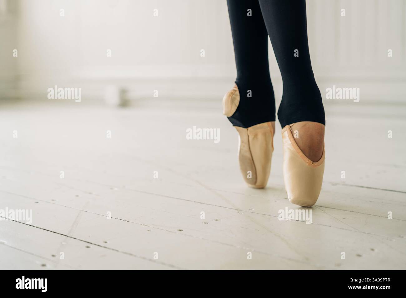 Gros plan des pieds d'une ballerine en chaussures pointe sur un plancher en bois Banque D'Images