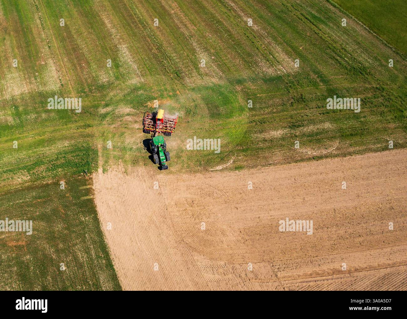 Tracteur labourant les champs agricoles, les lignes lisses du sol labouré mettent en évidence l'échelle du travail. Préparation saison de plantation, activité agricole. Aeri Banque D'Images Tracteur labourant les champs agricoles, les lignes lisses du sol labouré mettent en évidence l'échelle du travail. Préparation saison de plantation, activité agricole. Aeri Banque D'Images