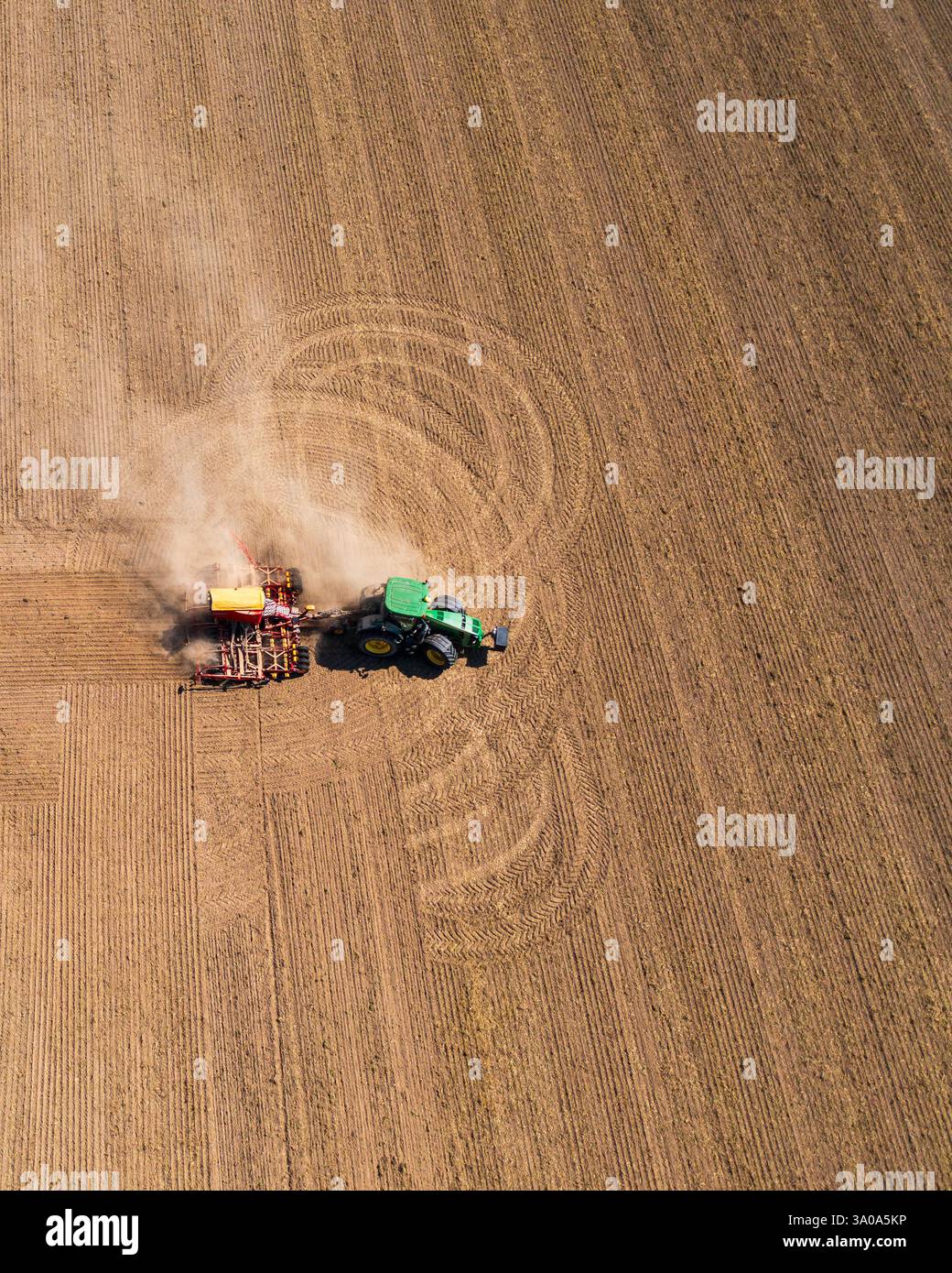 Tracteur labourant les champs agricoles, les lignes lisses du sol labouré mettent en évidence l'échelle du travail. Préparation saison de plantation, activité agricole. Aeri Banque D'Images Tracteur labourant les champs agricoles, les lignes lisses du sol labouré mettent en évidence l'échelle du travail. Préparation saison de plantation, activité agricole. Aeri Banque D'Images