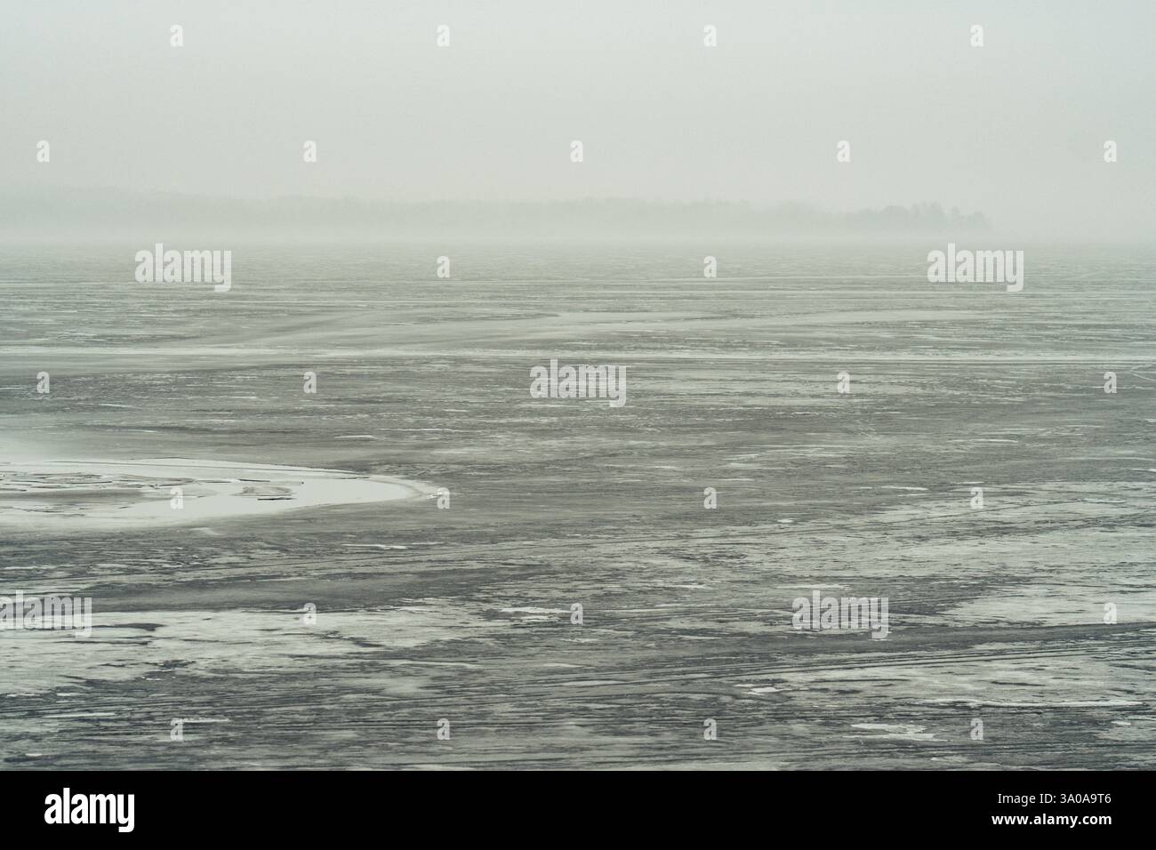 Magnifique paysage de début de printemps avec lac gelé et forêt brumeuse fumante sur le fond Banque D'Images