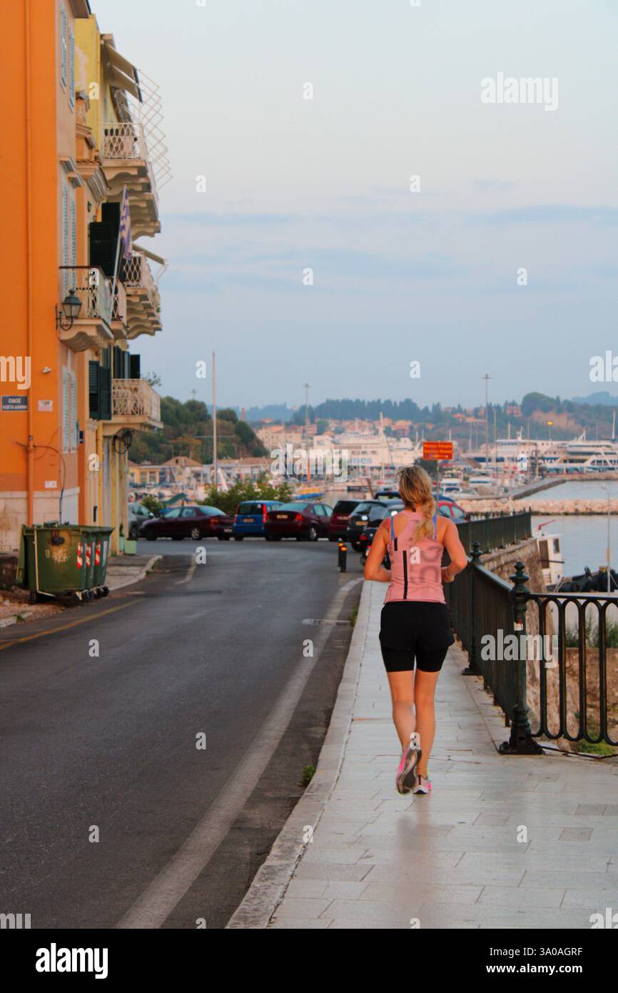 Jeune femme jogging tôt le matin à Arseniou Street, Corfou Banque D'Images