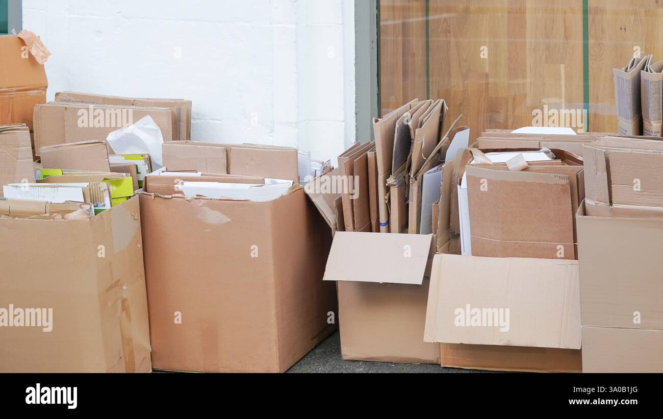 Piles de carton recyclé soigneusement empilées à l'extérieur pour la gestion des déchets. Banque D'Images