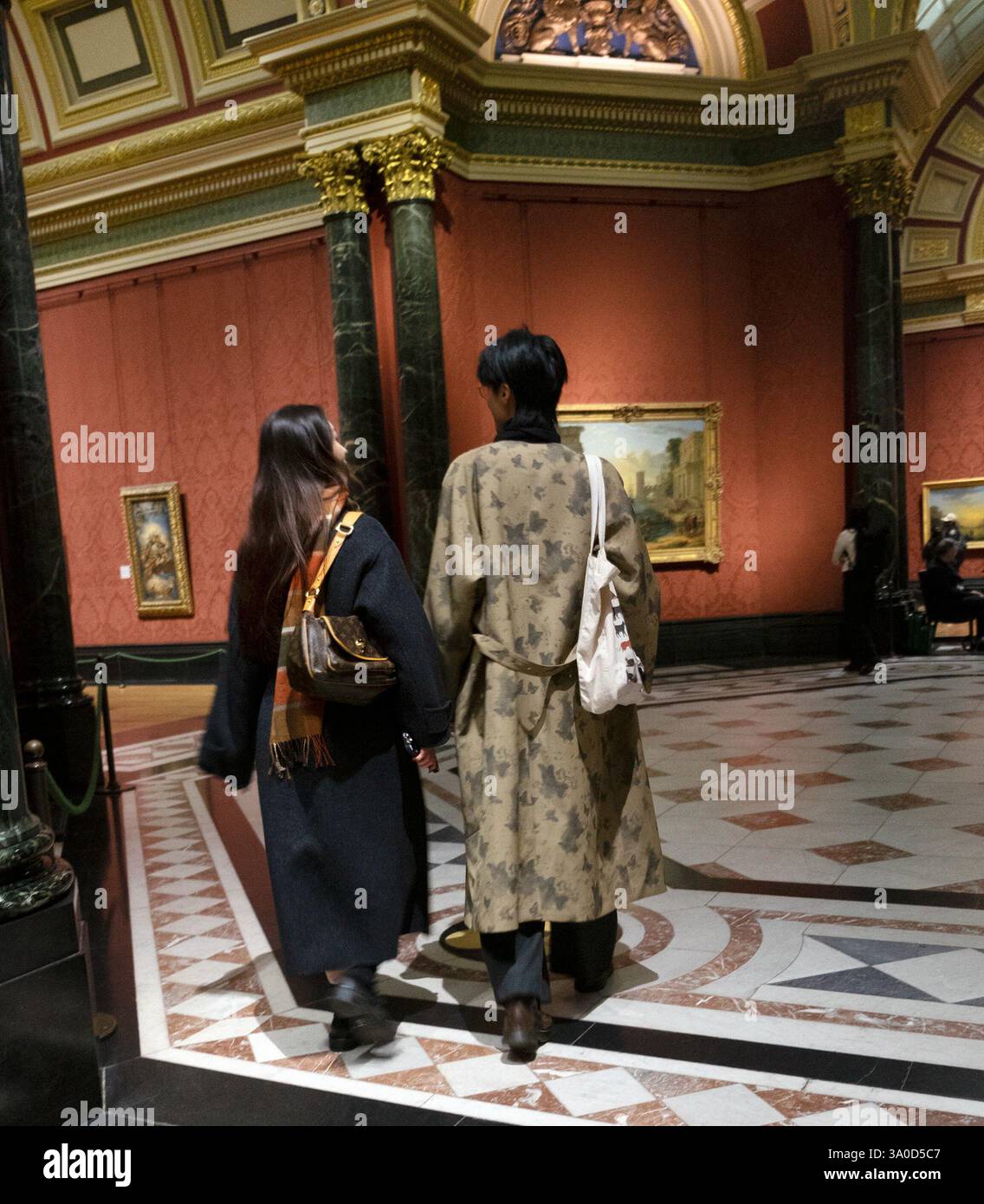Vue arrière d'un jeune couple japonais dans des vêtements à la mode manteaux d'hiver marchant à travers une salle de la National Gallery à Londres Angleterre KATHY DEWITT 2025 Banque D'Images Vue arrière d'un jeune couple japonais dans des vêtements à la mode manteaux d'hiver marchant à travers une salle de la National Gallery à Londres Angleterre KATHY DEWITT 2025 Banque D'Images