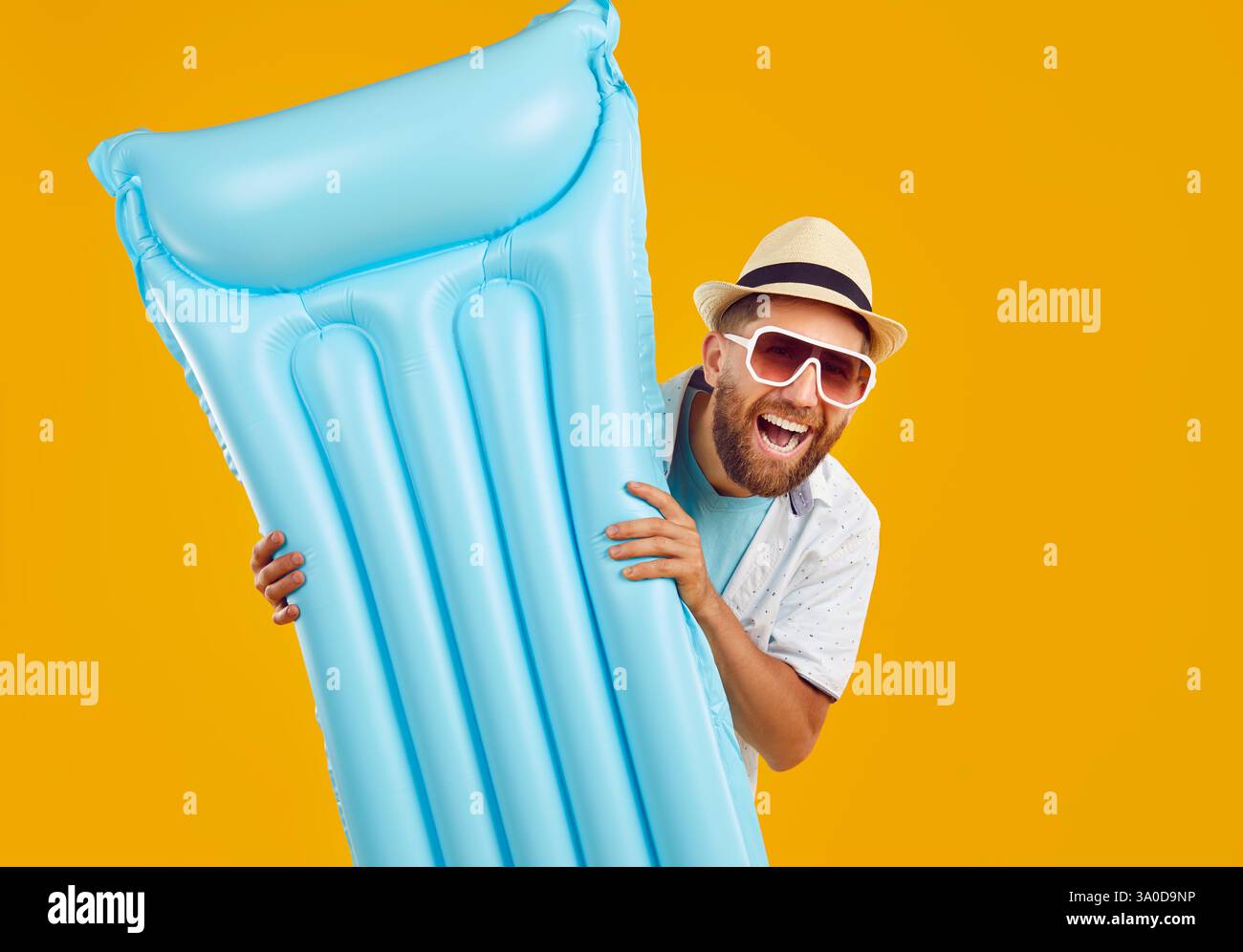 Homme heureux va bronzer sur matelas gonflable qu'il tient dans les mains pendant les vacances d'été Banque D'Images