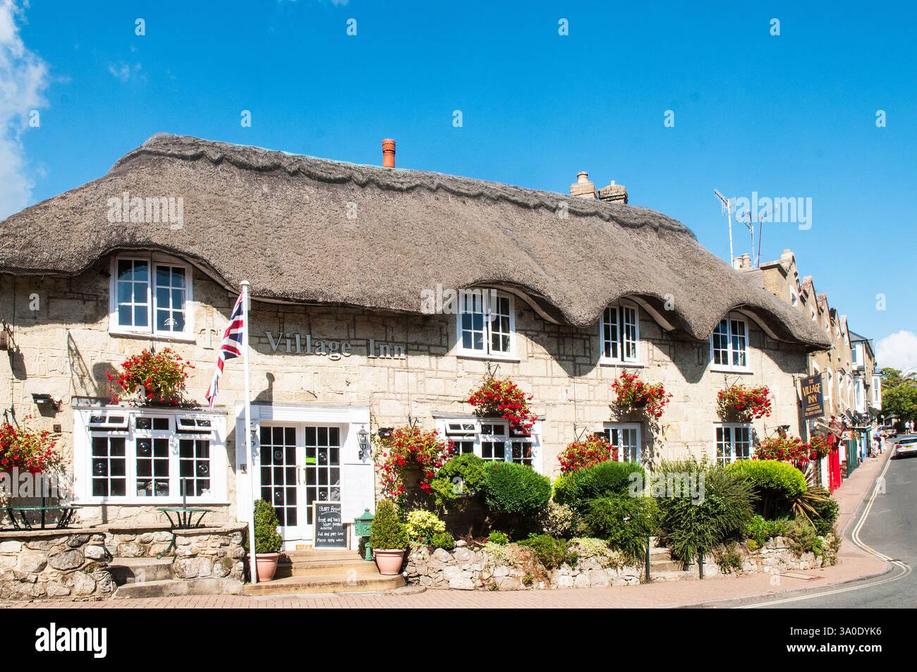 Le Village Inn avec un toit de chaume et beaucoup de paniers suspendus et un drapeau Union Jack à l'extérieur dans le vieux village Shanklin sur l'île de White Banque D'Images