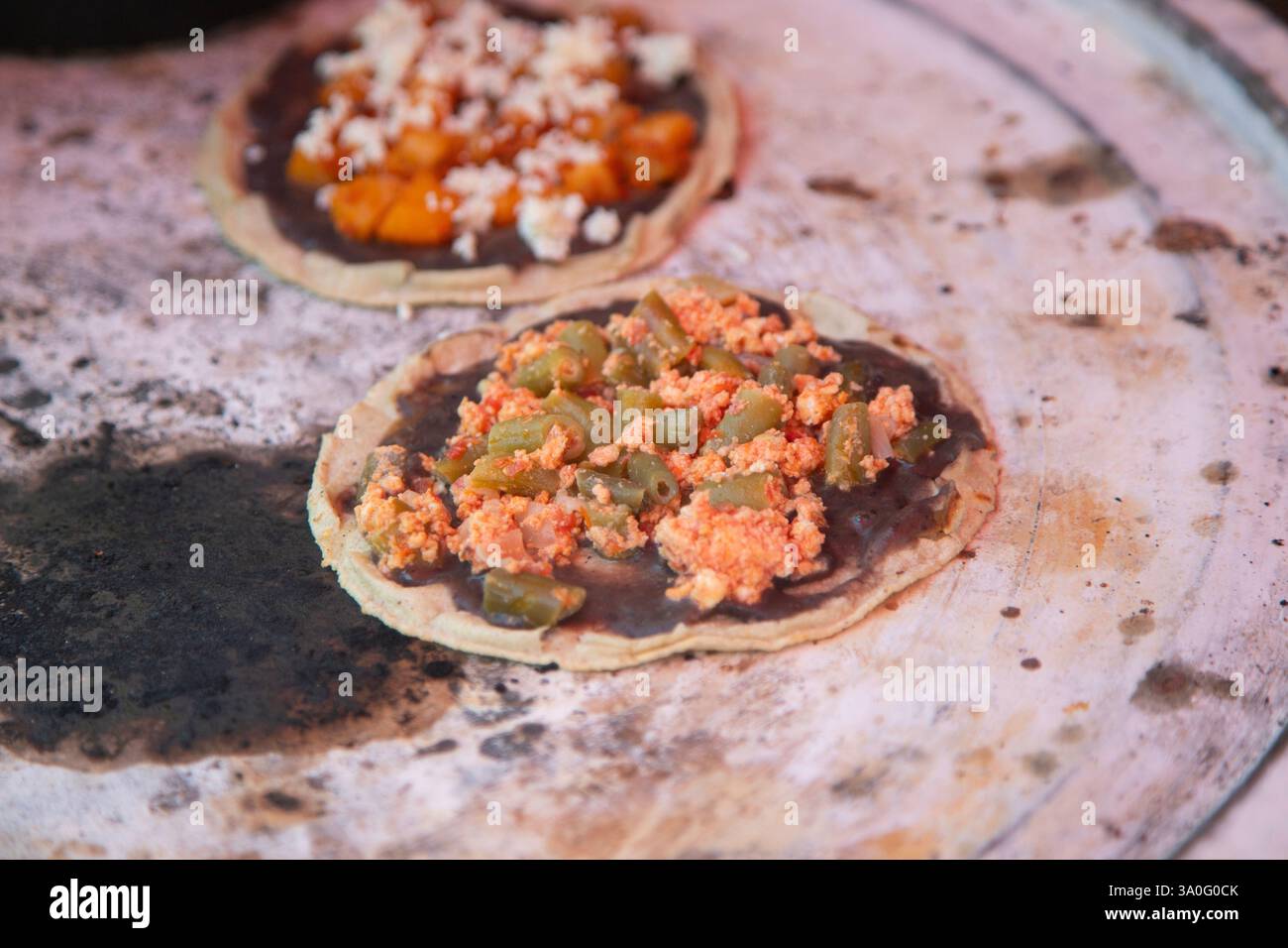 Cuisine memelas au marché d'Oaxaca Central de Abastos avec fromage local, porc et légumes. Banque D'Images