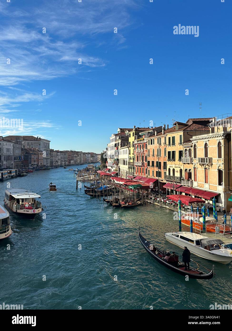 Balade en gondole à travers le Grand canal de Venise au coucher du soleil, avec des bâtiments historiques bordant l'eau et une vue panoramique sur le pont du Rialto. - Image de stock capturée avec un smartphone
