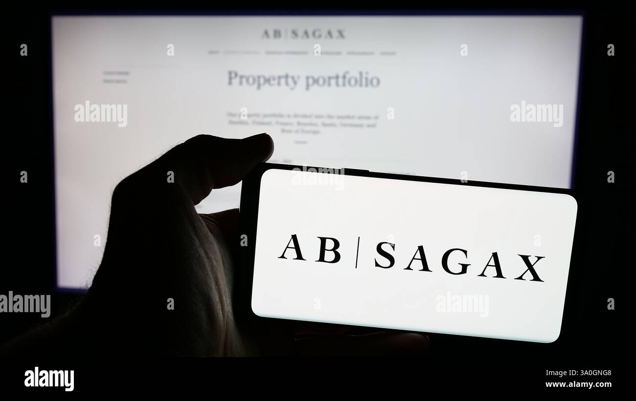 Allemagne. 2 décembre 2024. Dans cette illustration photo, une personne tient un téléphone portable avec le logo de la société immobilière suédoise AB sagax sur l'écran en face de la page Web de l'entreprise. (Crédit image : © timon Schneider/SOPA images via ZUMA Press Wire) USAGE ÉDITORIAL SEULEMENT ! Non destiné à UN USAGE commercial ! Banque D'Images