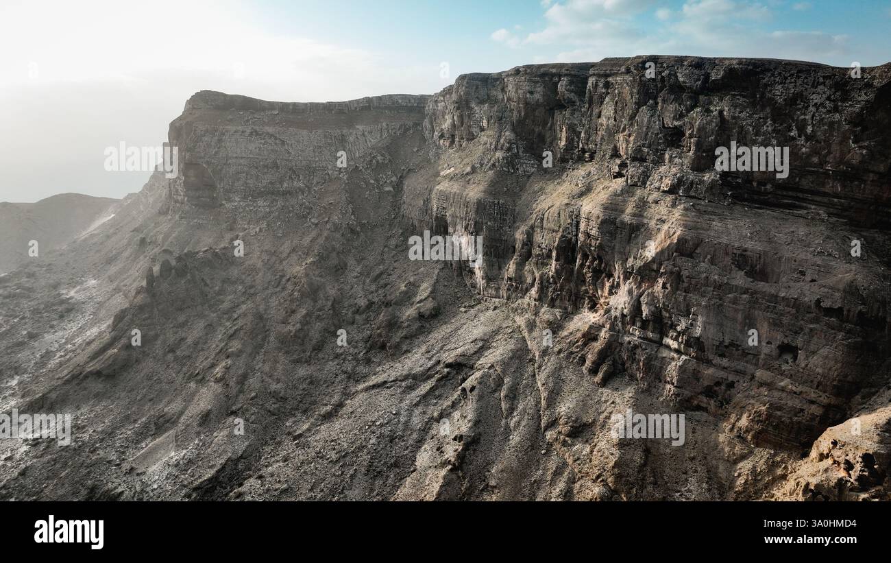De belles falaises rocheuses s'élèvent majestueusement sur l'île de Socotra, mettant en valeur un paysage unique et intact baigné de soleil. Banque D'Images